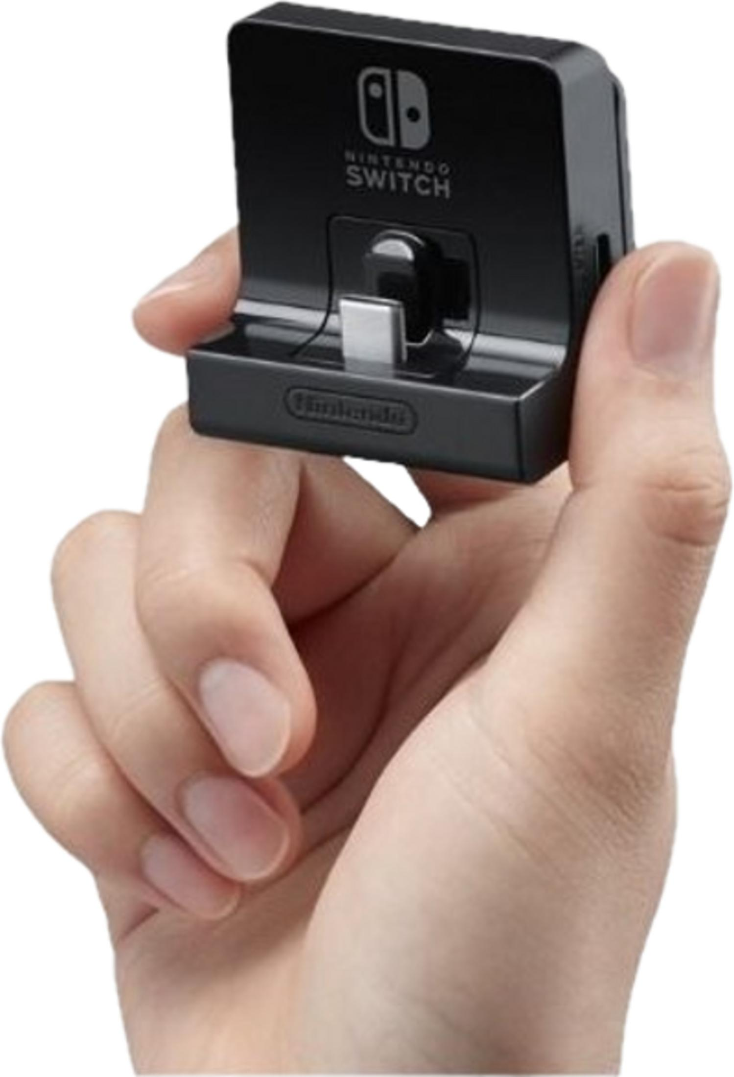 Eine Hand hält eine schwarze Nintendo Switch Dock mit USB-C Anschluss.
