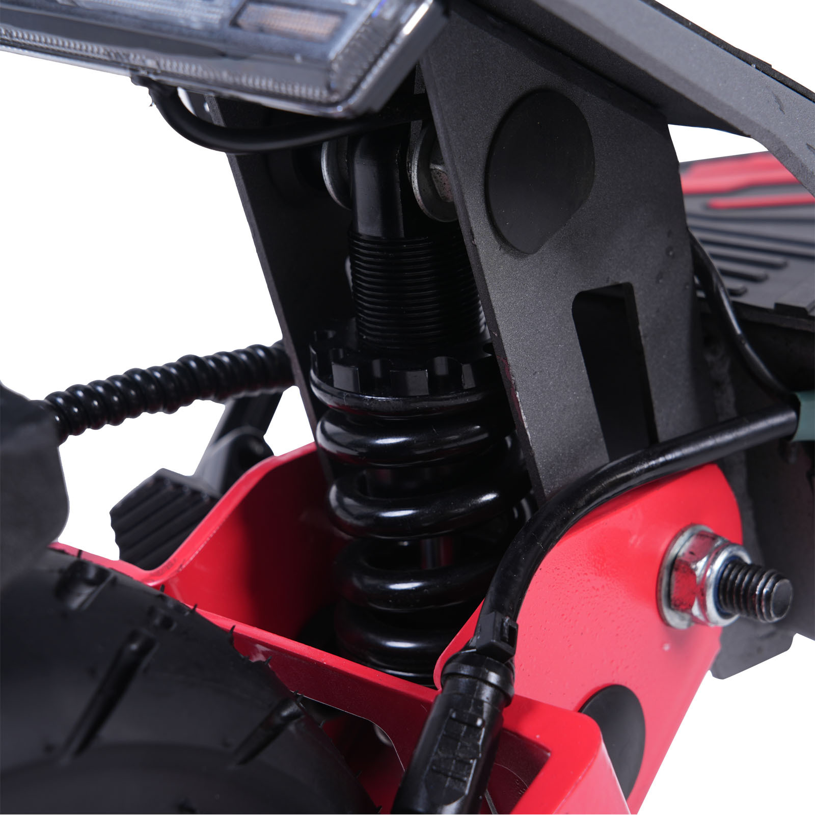 Zbliżenie na system amortyzacji czerwonego skutera elektrycznego z czarnym kołem.