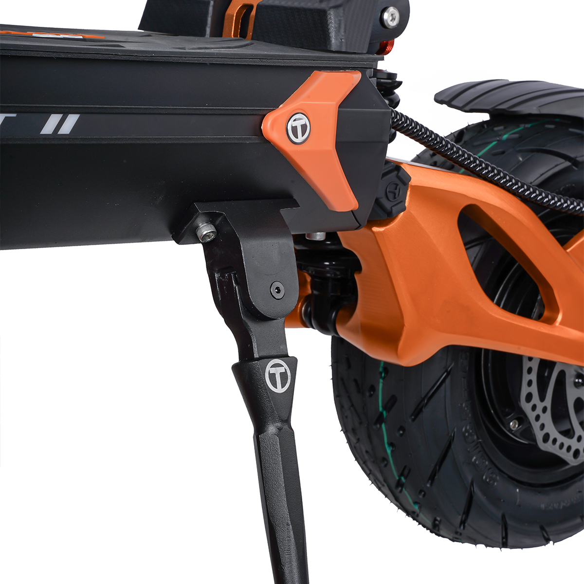 Zbliżenie na pomarańczową ramę, czarny podest i stopkę hulajnogi elektrycznej.