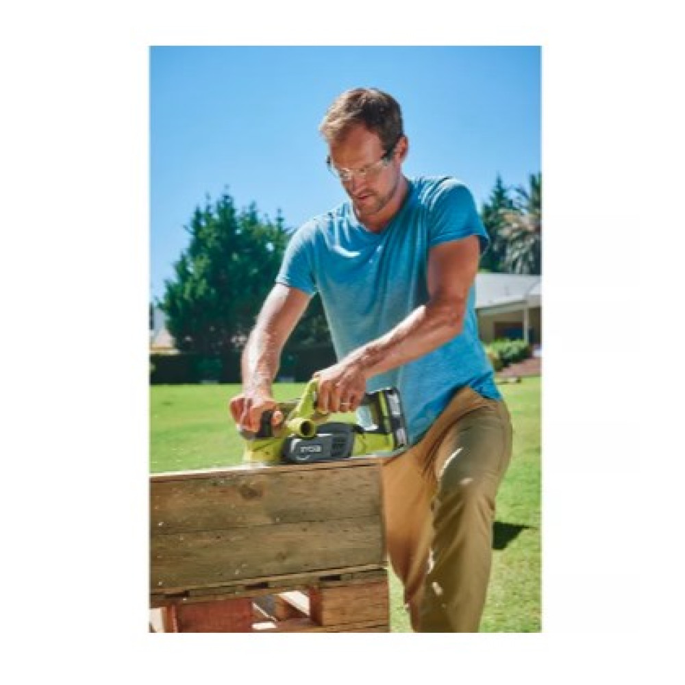 Uomo pialla legno all'aperto con un elettroutensile.