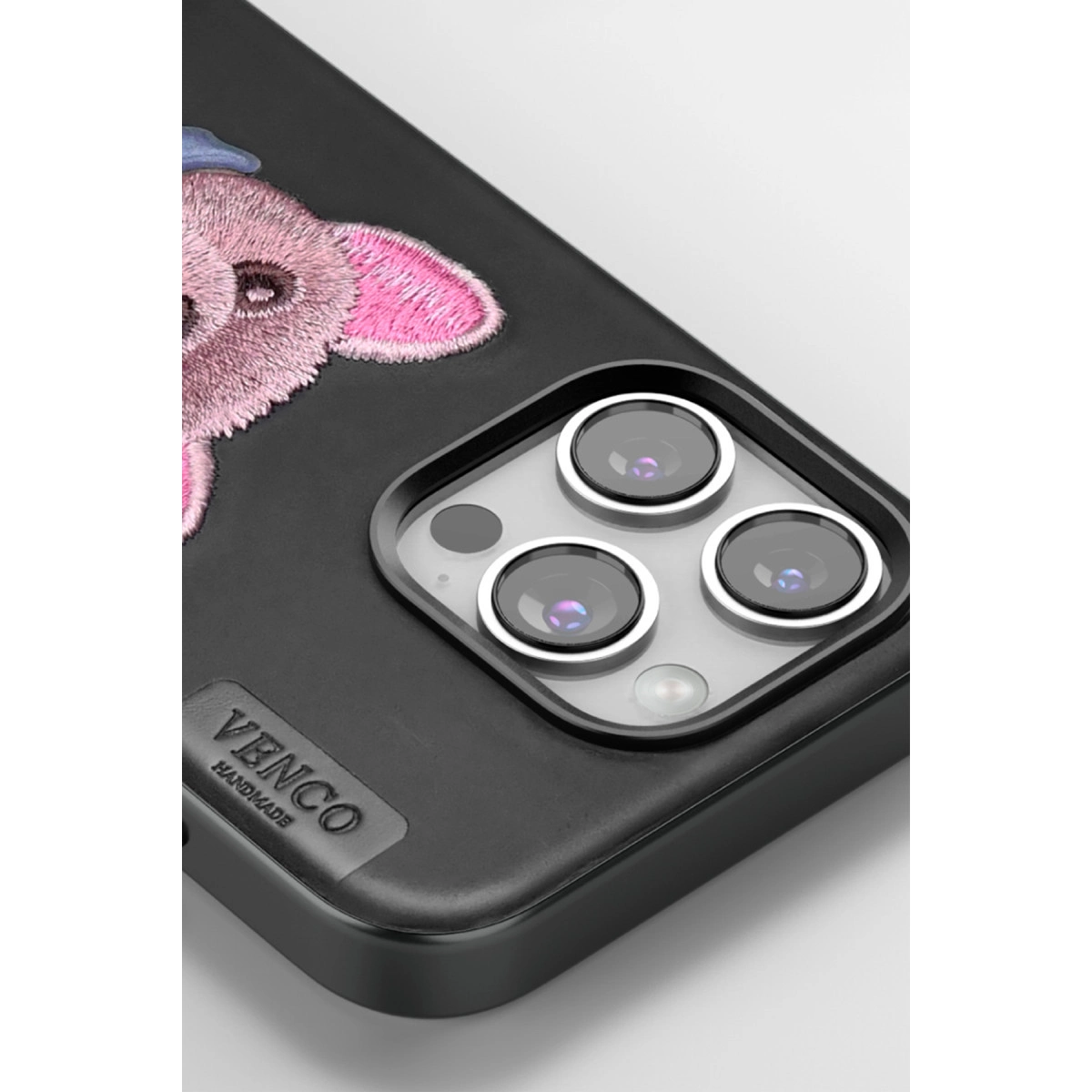 Pembe fil nakışlı ve üç kamera lensli siyah telefon kılıfı.