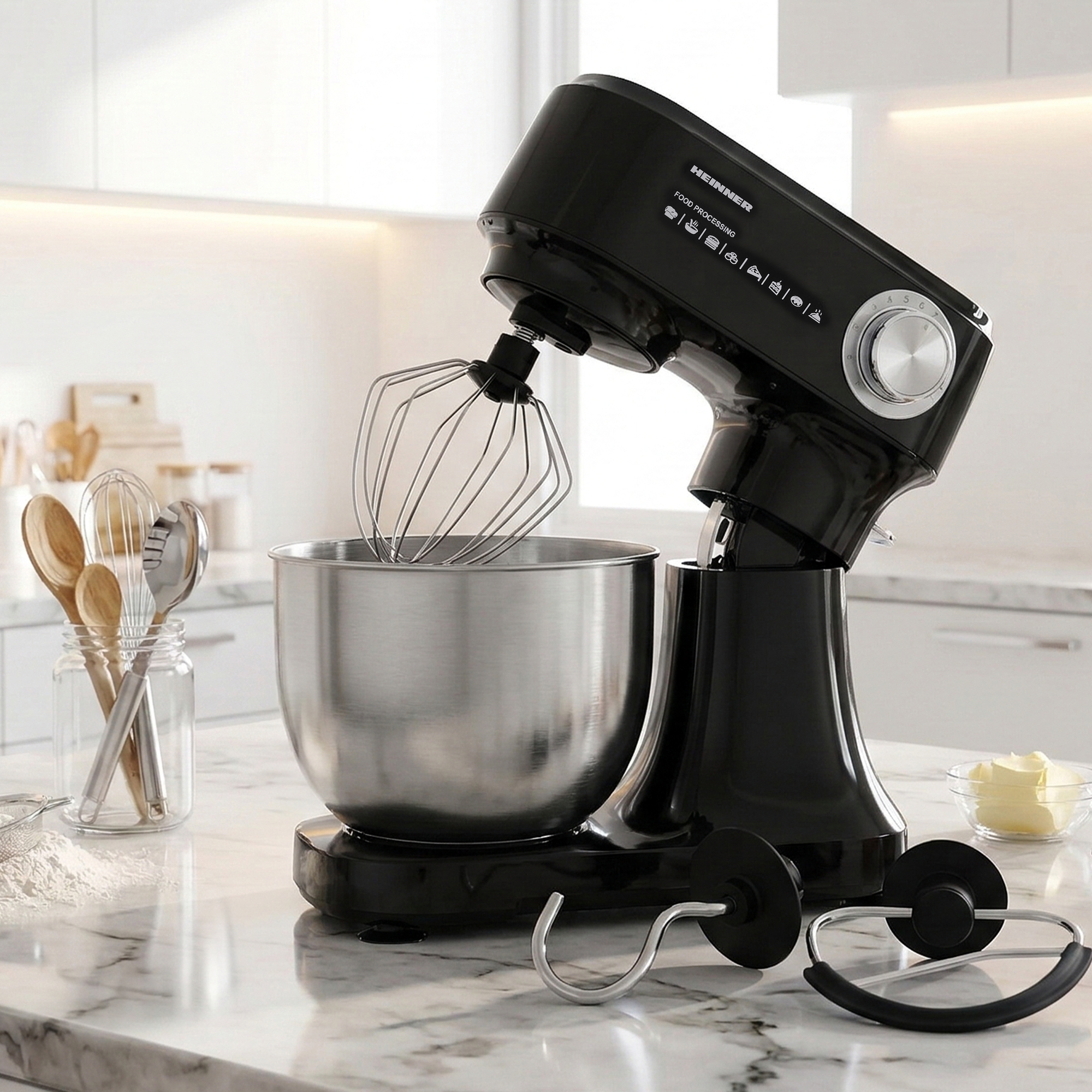 A black stand mixer with a stainless steel bowl and whisk attachment.