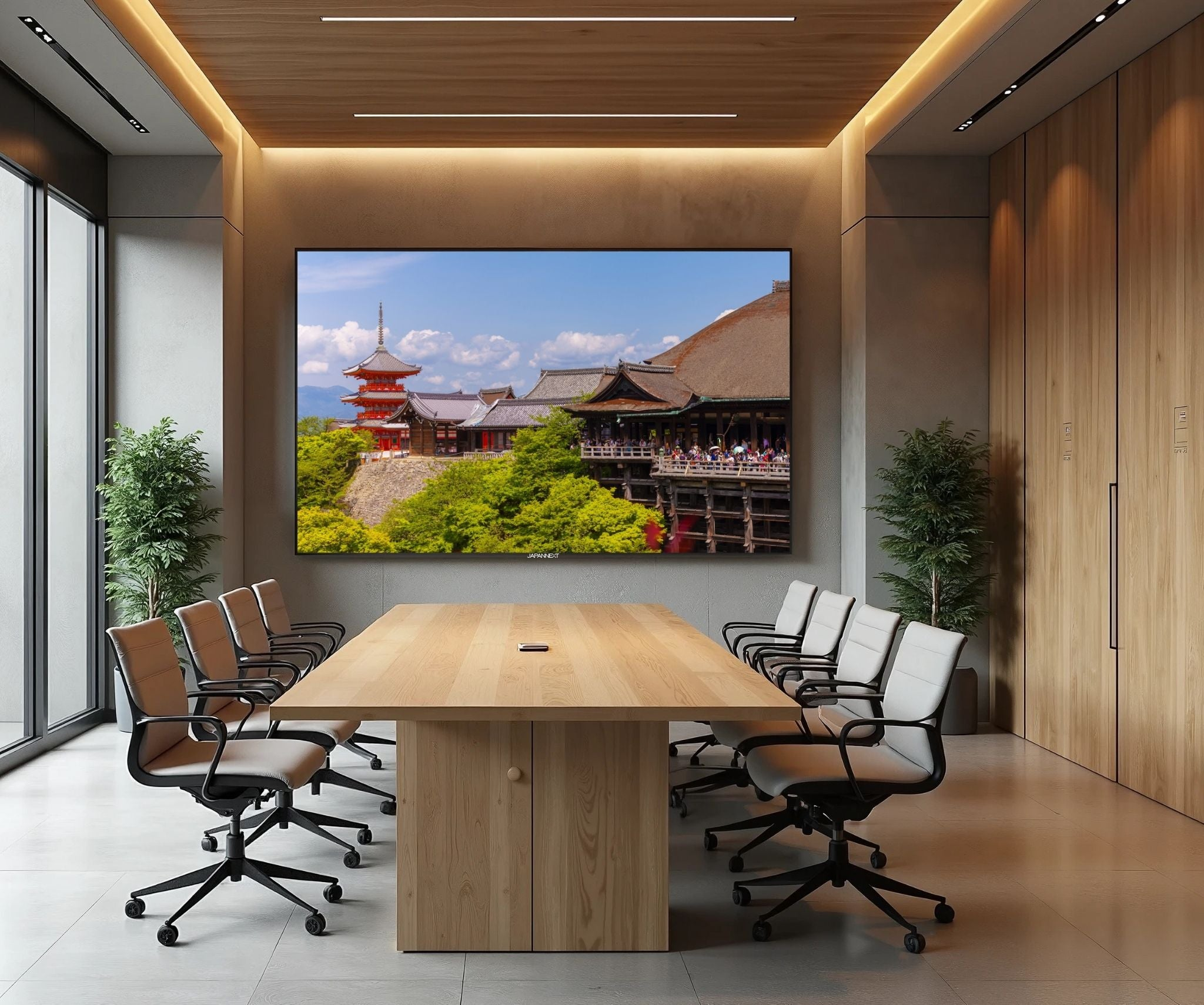 Sala de conferencias moderna con pantalla grande que muestra un templo japonés.