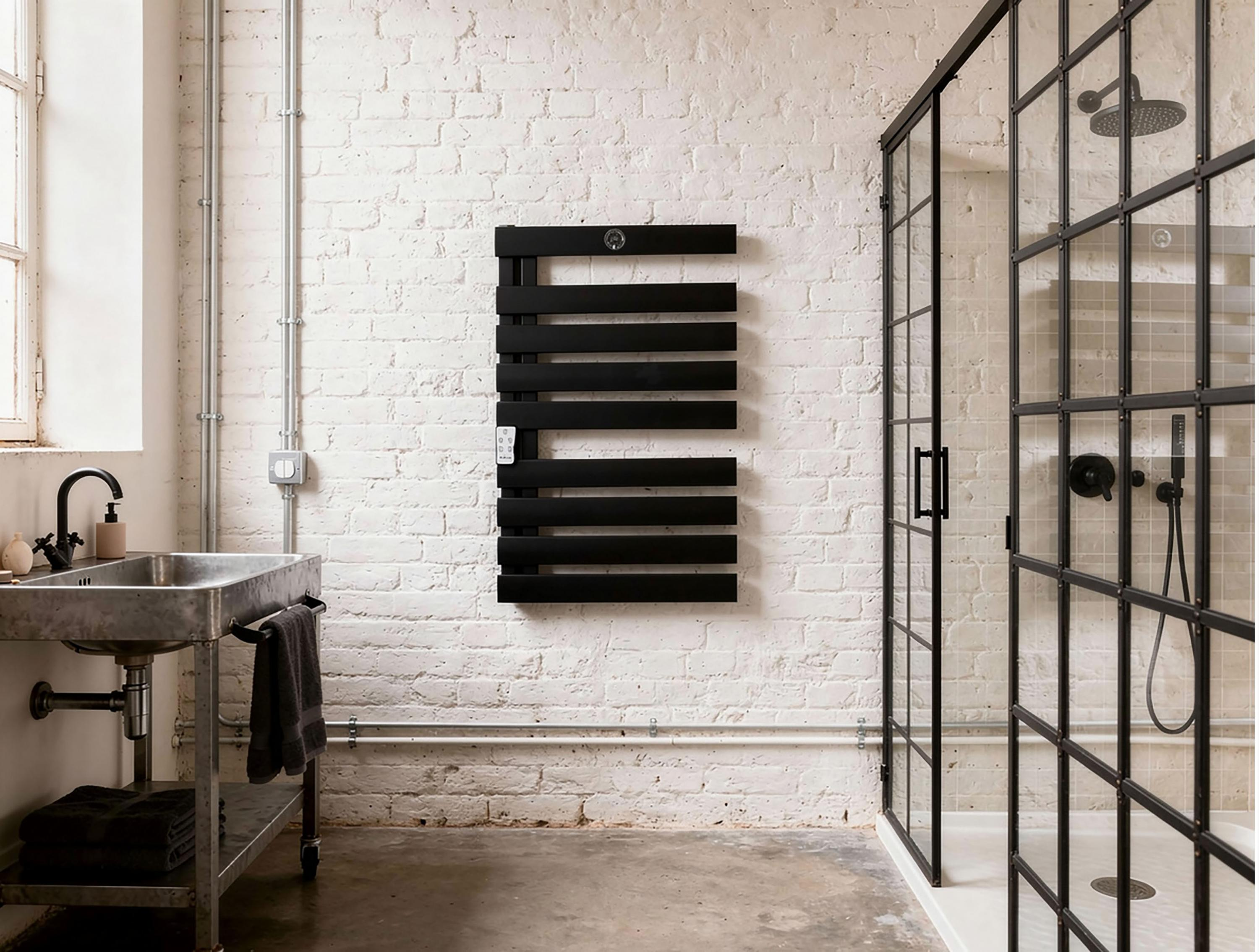 Baño moderno con pared de ladrillo blanco, toallero negro, lavabo y cabina de ducha.