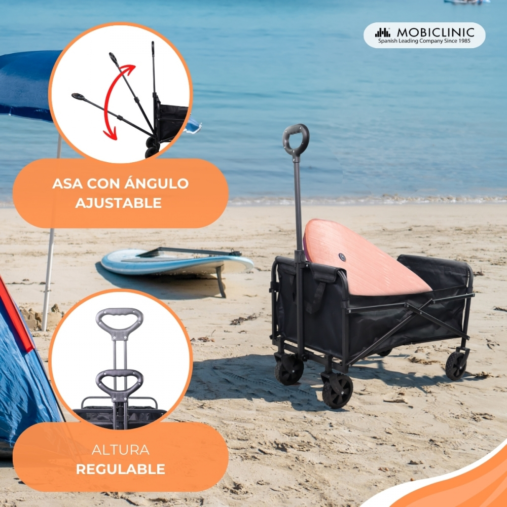 Un carro de playa negro con tabla de surf en la playa, mar y cielo al fondo.