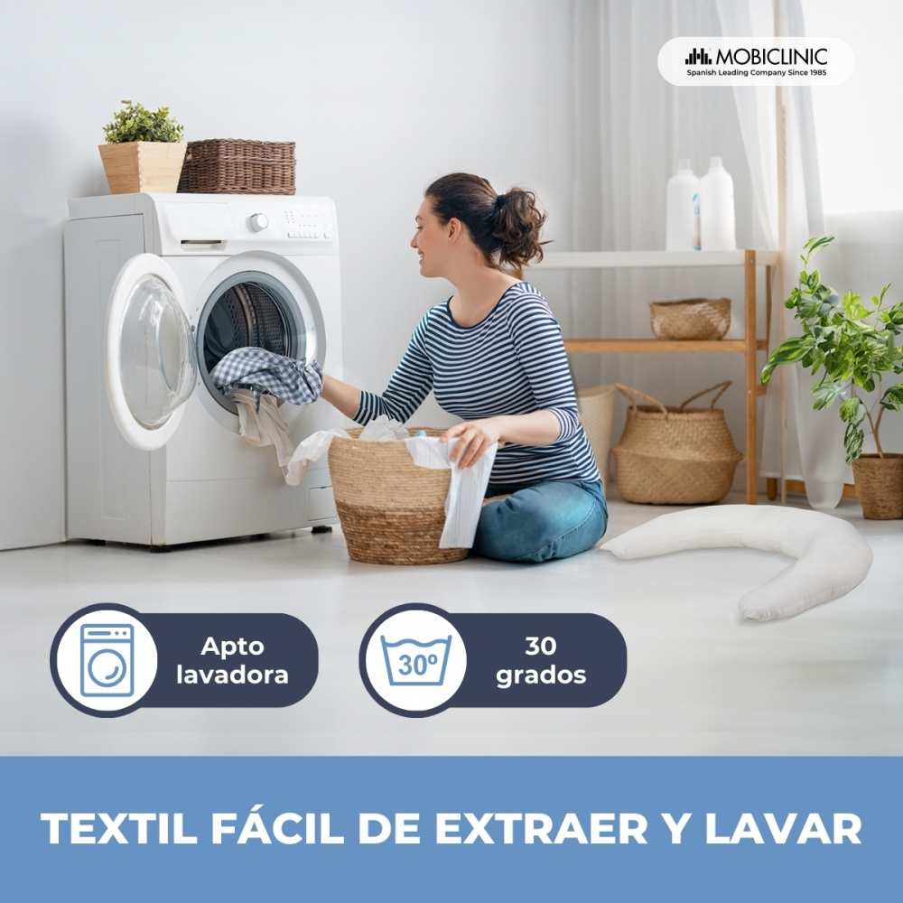 Una mujer mete ropa en una lavadora, con una cesta de ropa al lado.