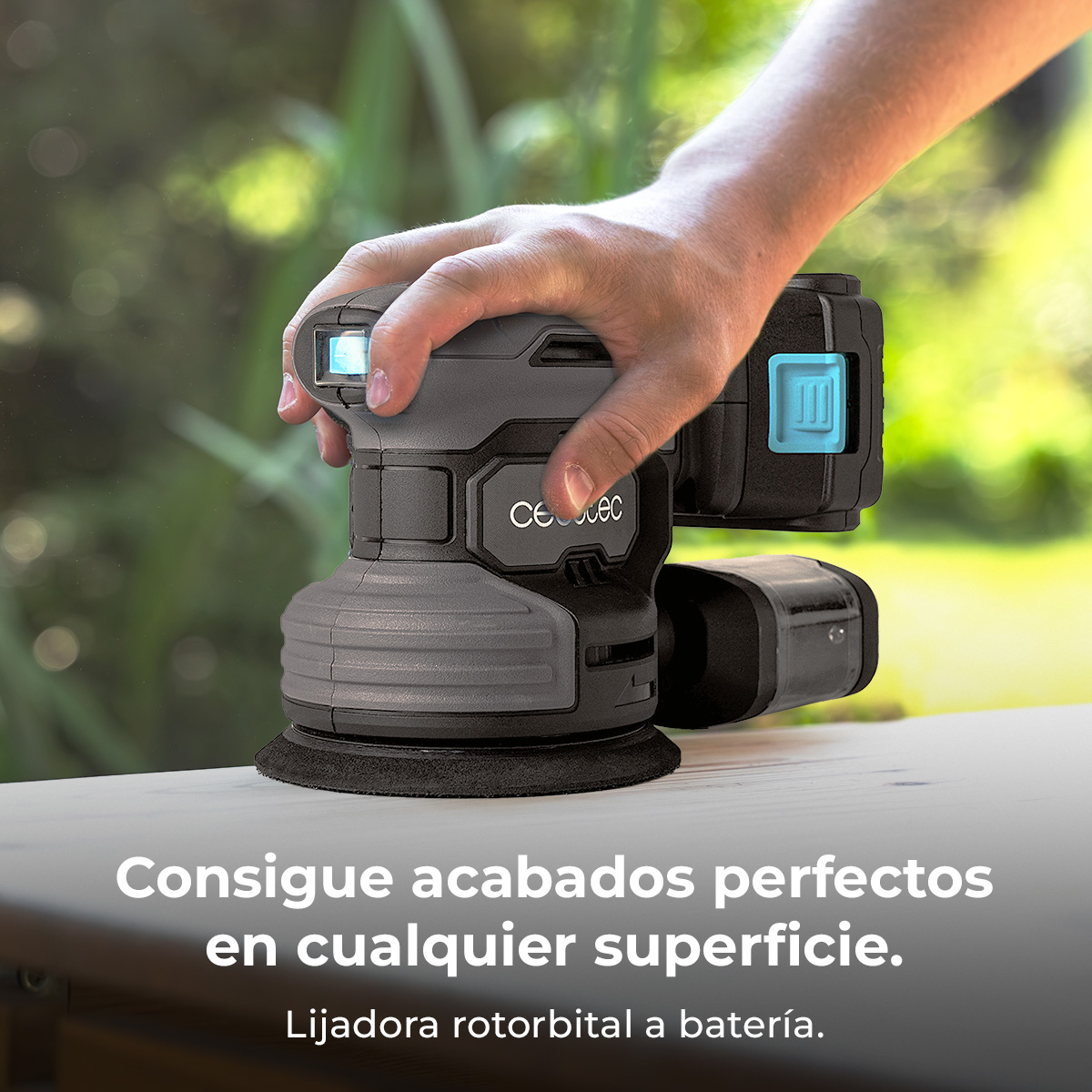 Mano che tiene levigatrice a batteria con luce blu su superficie legno.