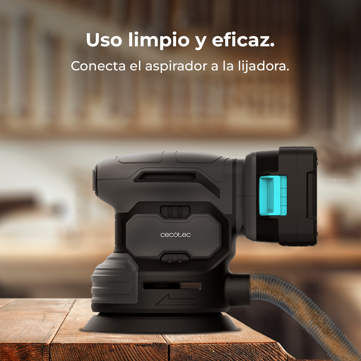 Levigatrice nera con accento blu e tubo su tavolo di legno.