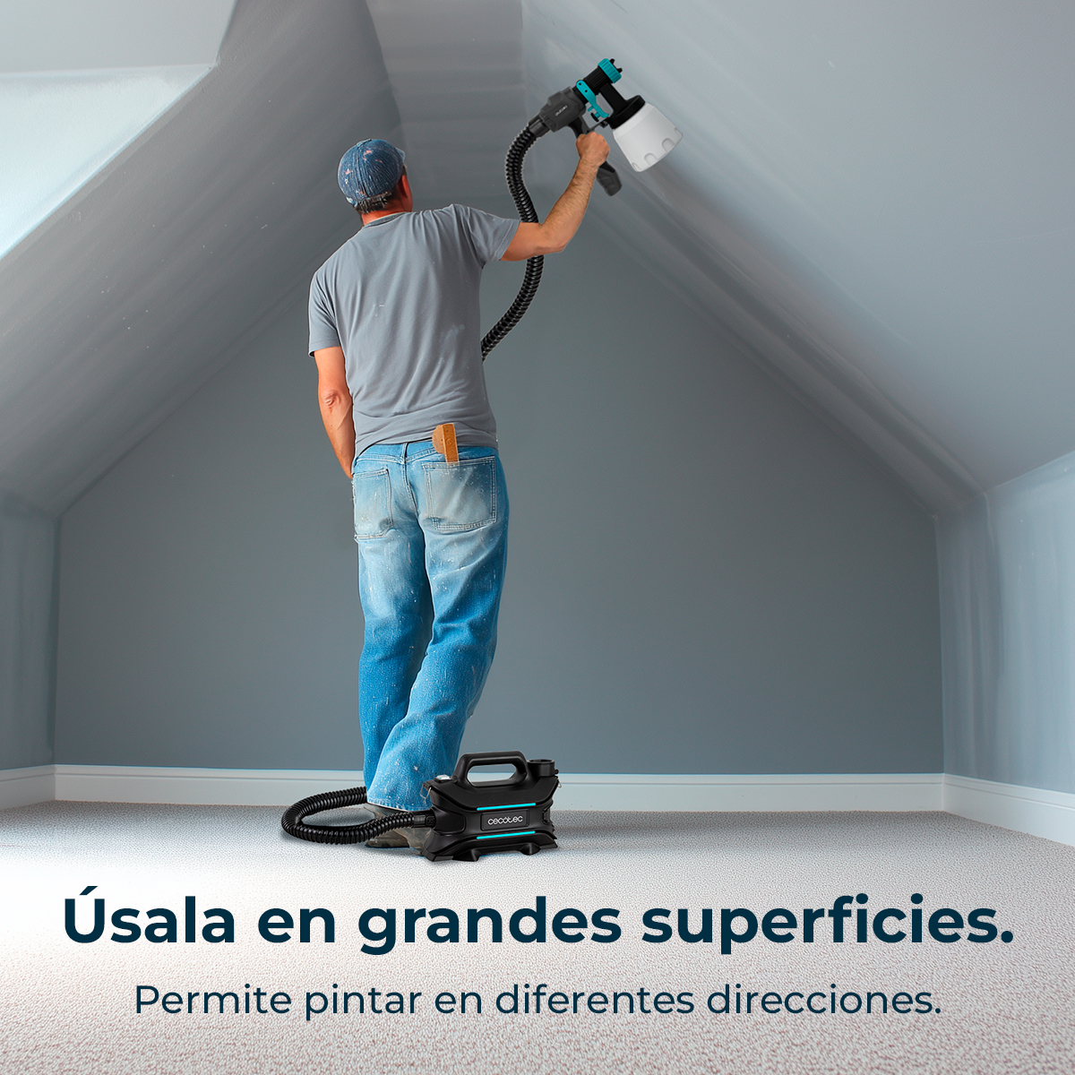 Hombre pintando techo con pistola de pintura. Unidad negra en el suelo.