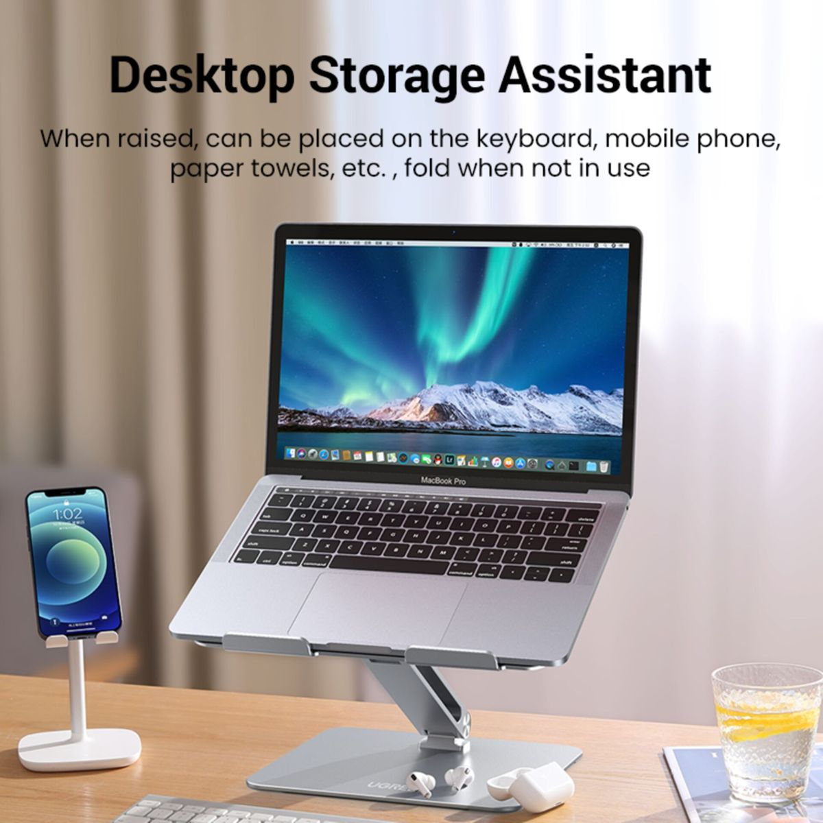 Stojak na laptopa z uchwytem na telefon i słuchawkami na biurku.