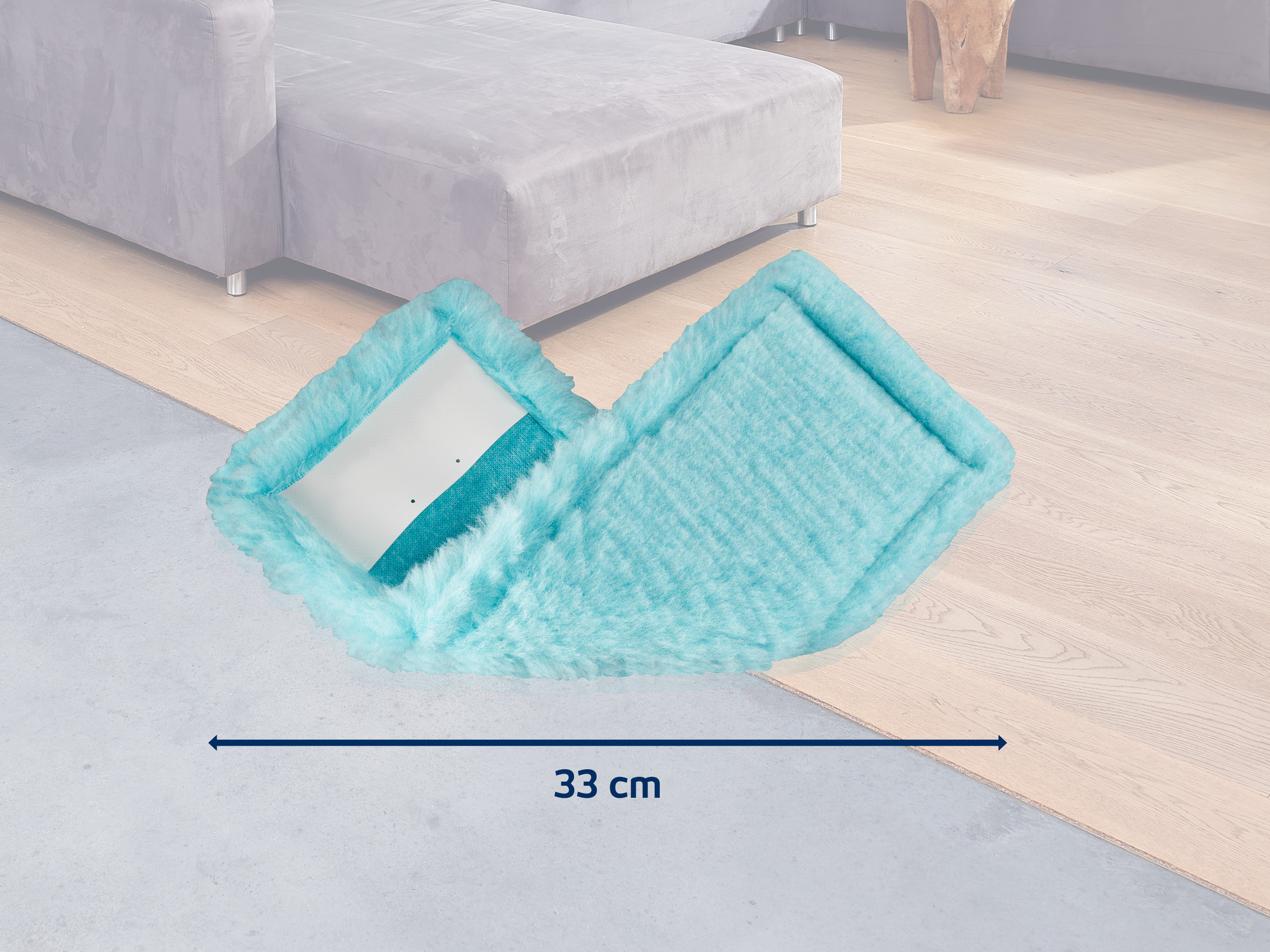 Türkisblaue Wischmopp-Auflage mit flauschiger Textur auf Holzboden. 33 cm.