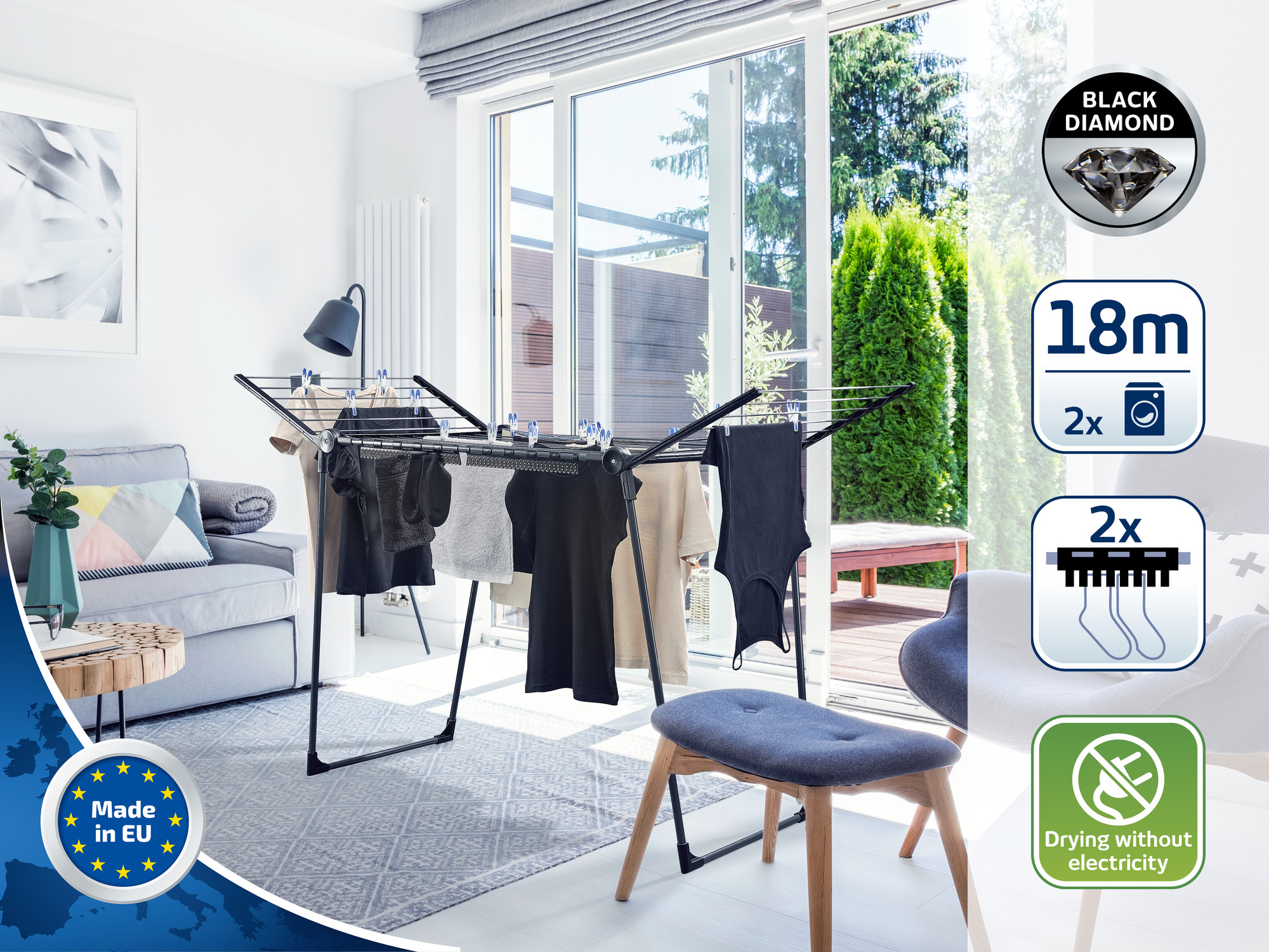 Ein Wäscheständer mit Kleidung steht in einem Wohnzimmer vor einer Terrassentür.