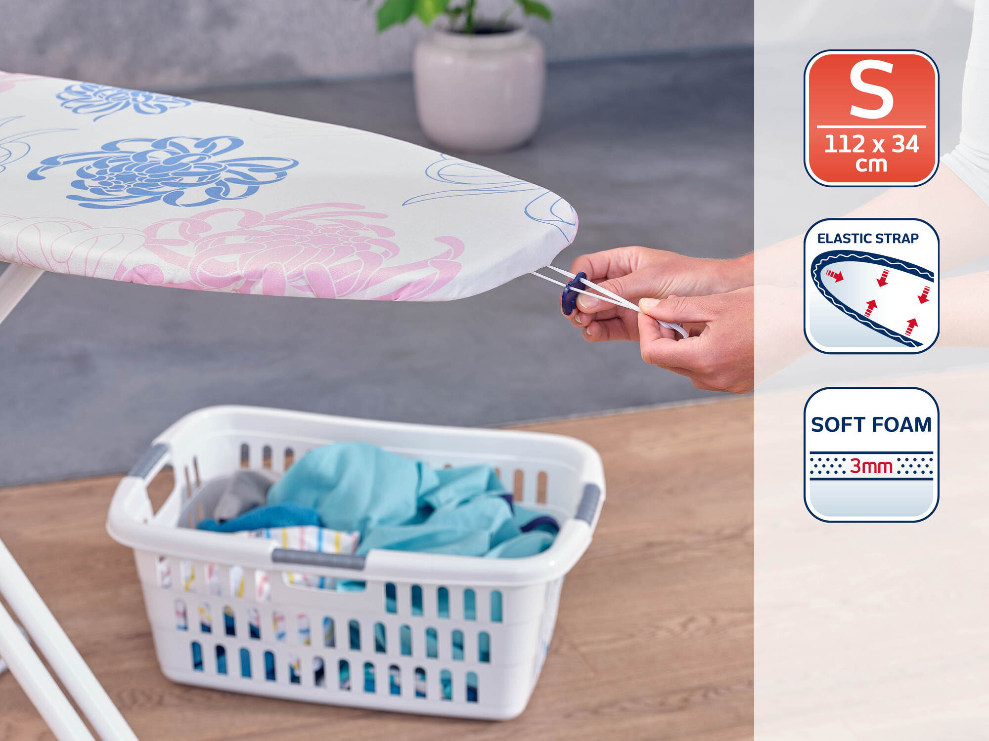 Deska do prasowania we wzór kwiatowy, kosz na pranie i ręce mocujące sznurek.