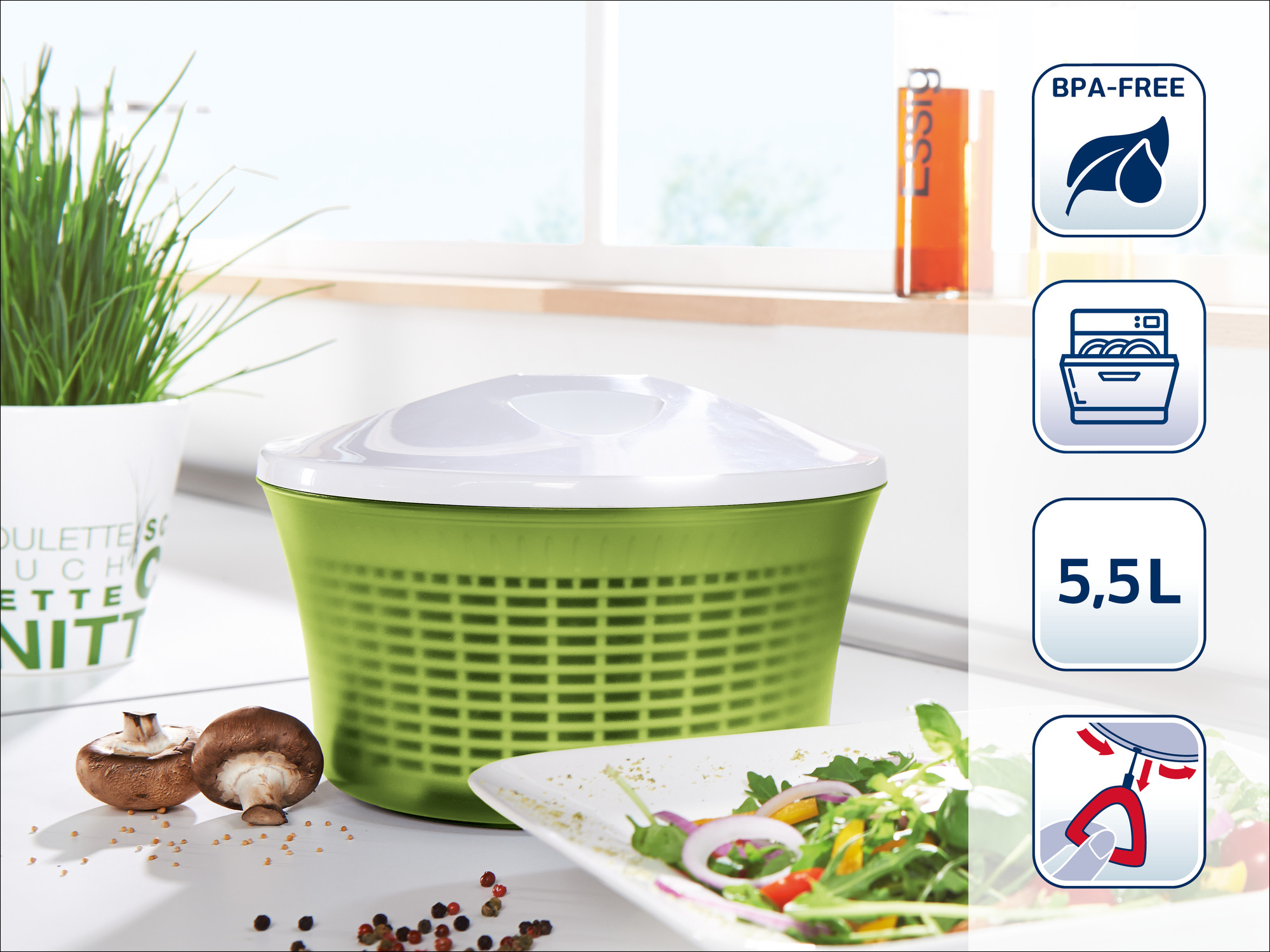 Grüne Salatschleuder mit weißem Deckel, Pilzen, Salat und Gewürzen.