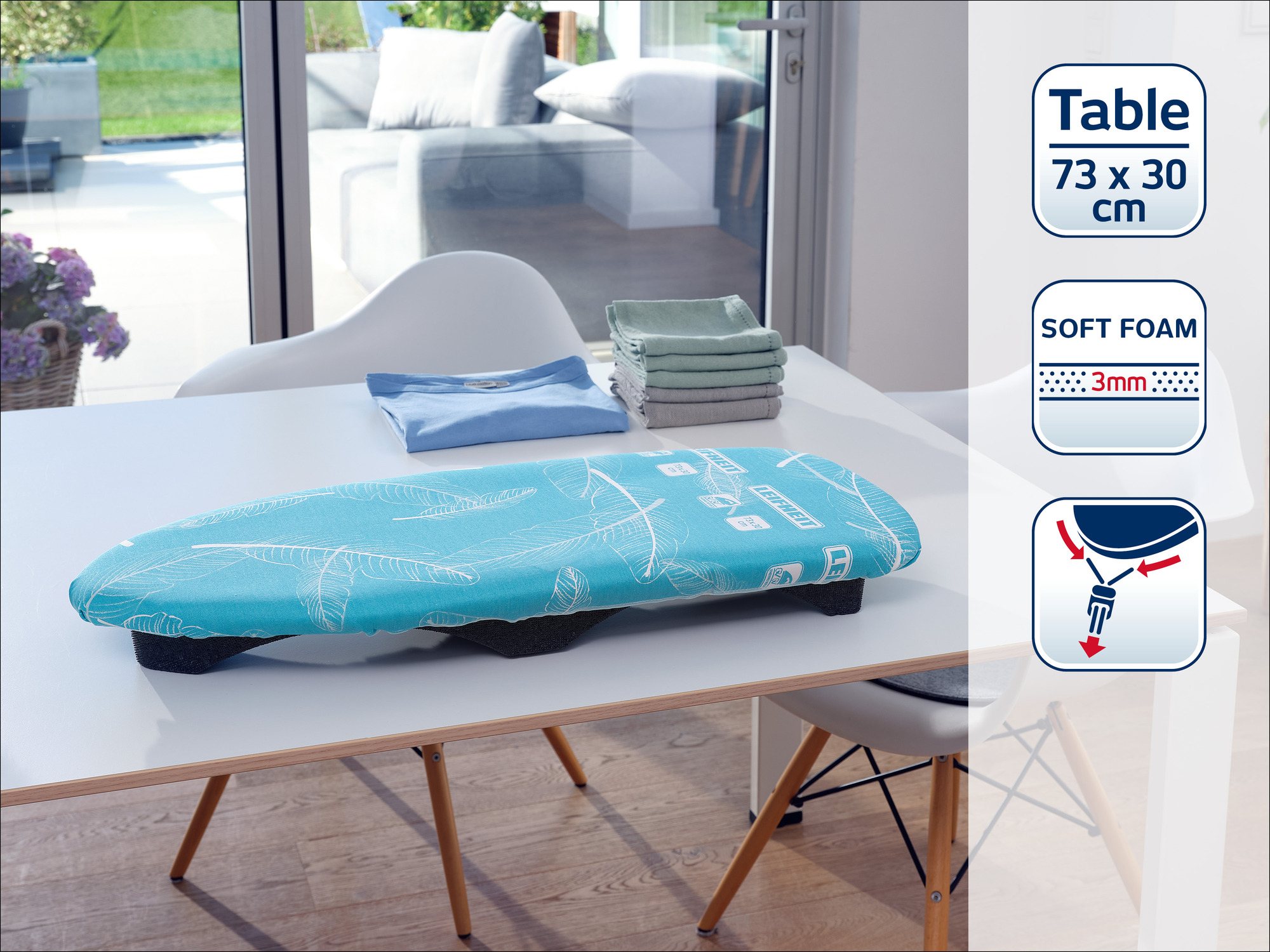 Bügelleicht Tischbügelbrett mit Feder-Design, blau. Auf einem weißen Tisch liegend.