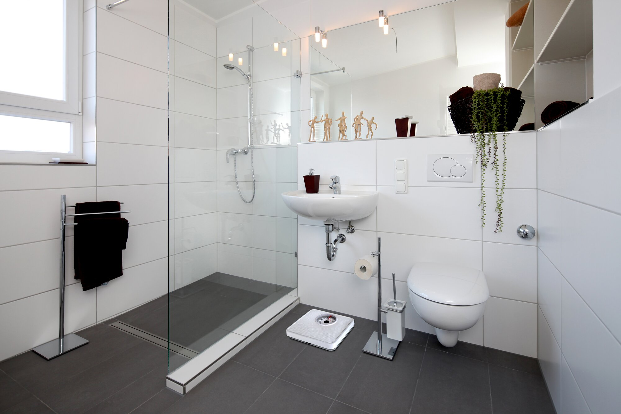 Nowoczesna łazienka z prysznicem, umywalką, toaletą i wagą.