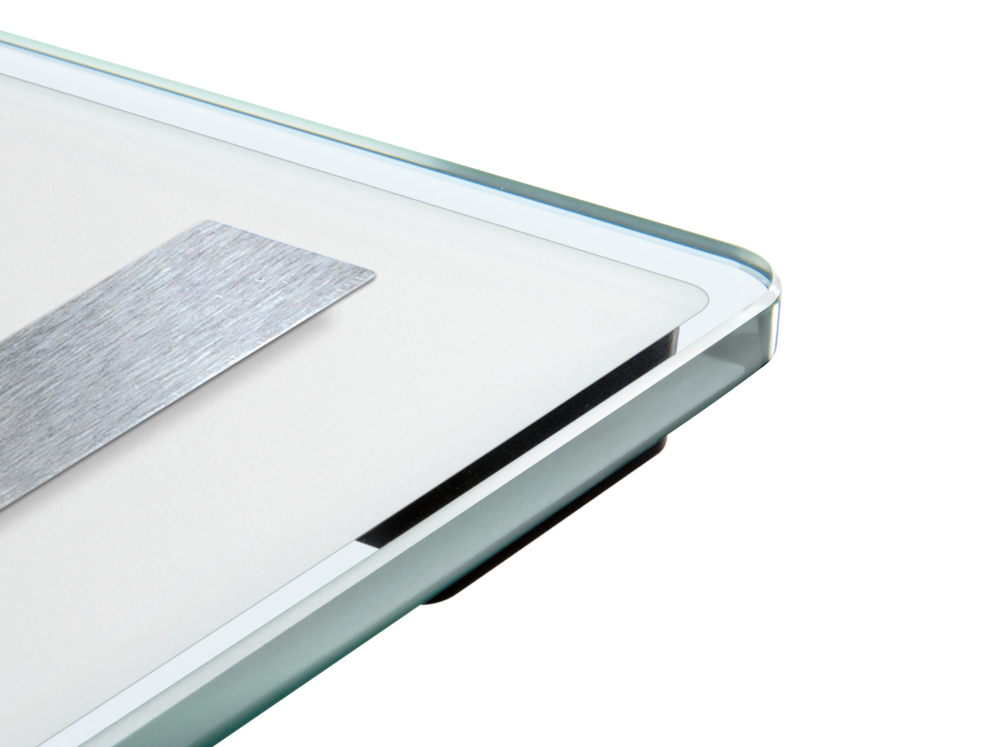 Zbliżenie wagi cyfrowej z szklaną powierzchnią i metalowym elementem.