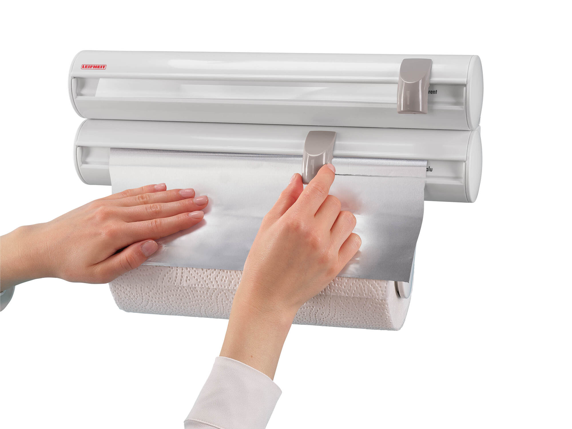 Hände ziehen Aluminiumfolie von einer Rolle über Küchenpapier.