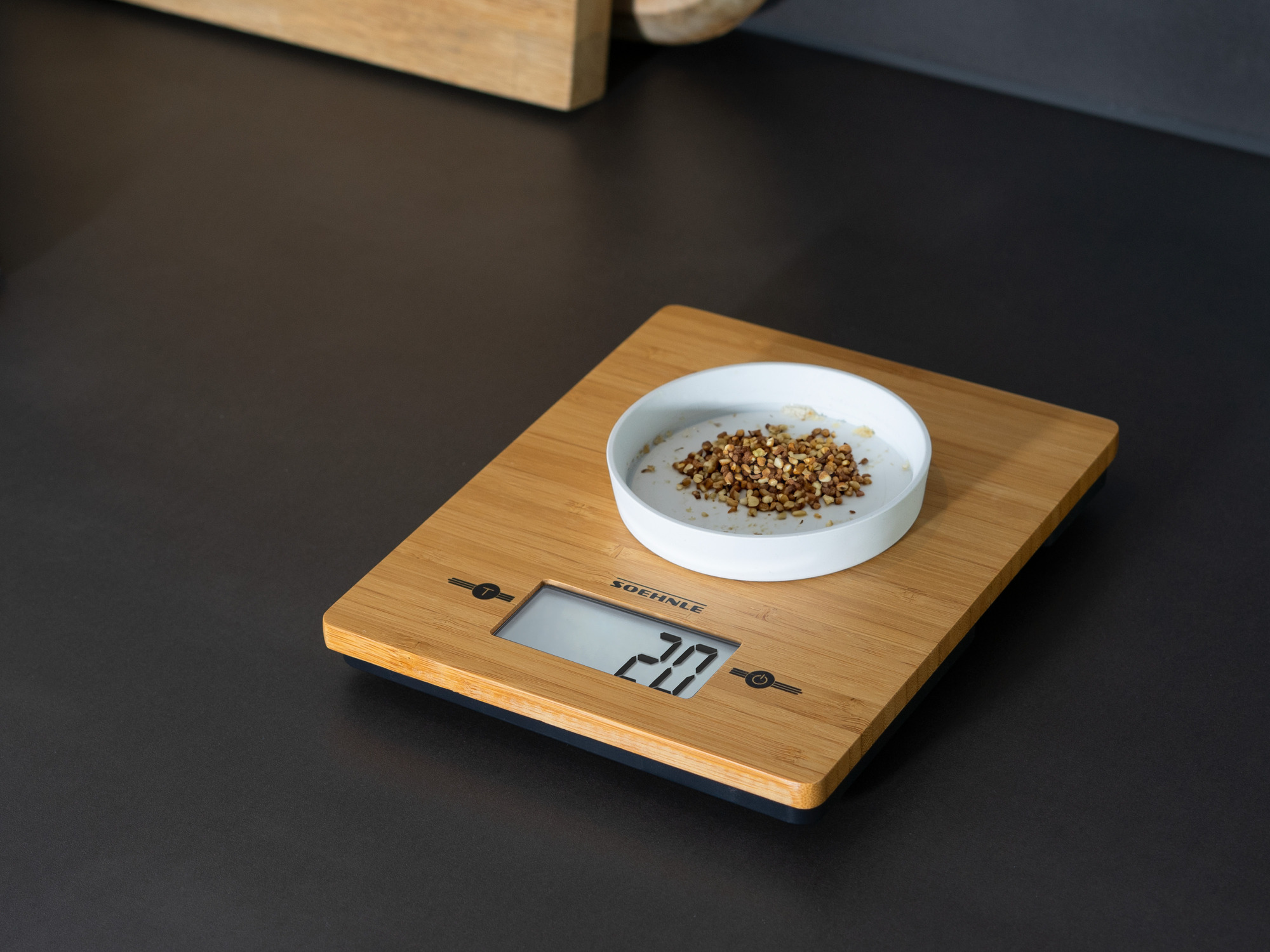 Eine Küchenwaage aus Holz mit 20g Inhalt in einer Schale.