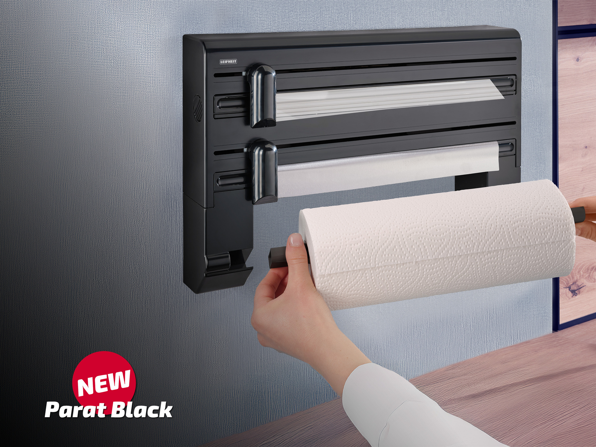 Un porta rotoli da cucina nero con un nuovo rotolo di carta inserito.