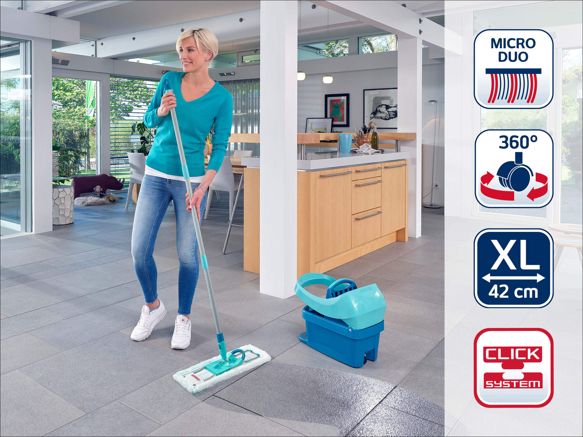 Eine Frau mit einem Mopp reinigt einen grauen Fliesenboden in einem modernen Haus.