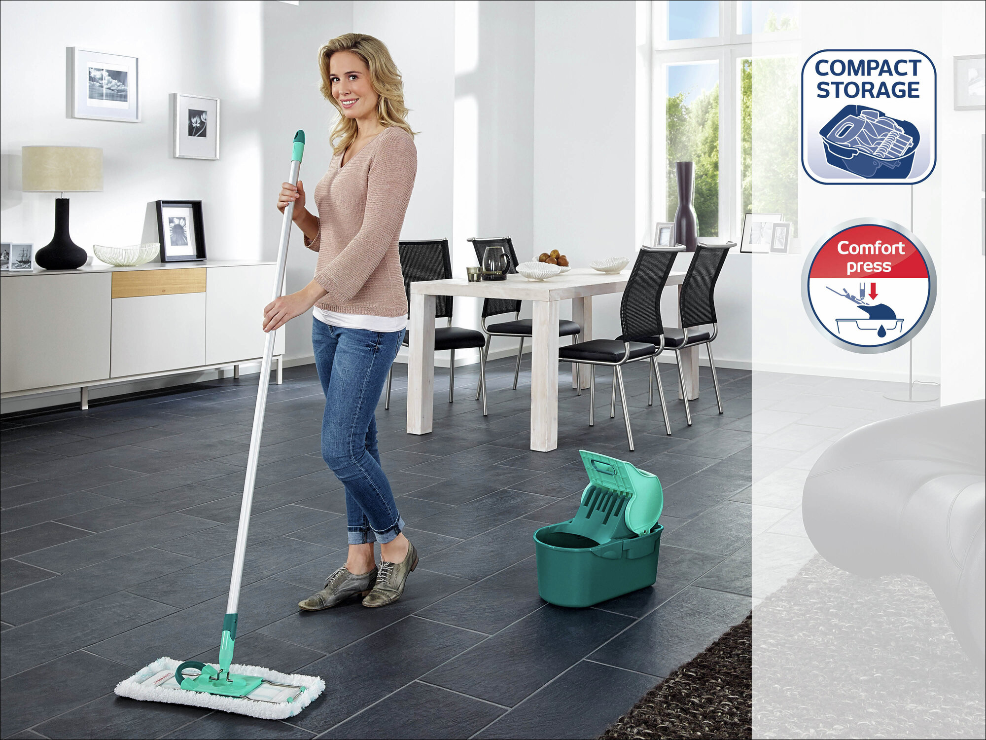 Eine Frau mit einem Mopp und Eimer in einem modernen Wohnzimmer.