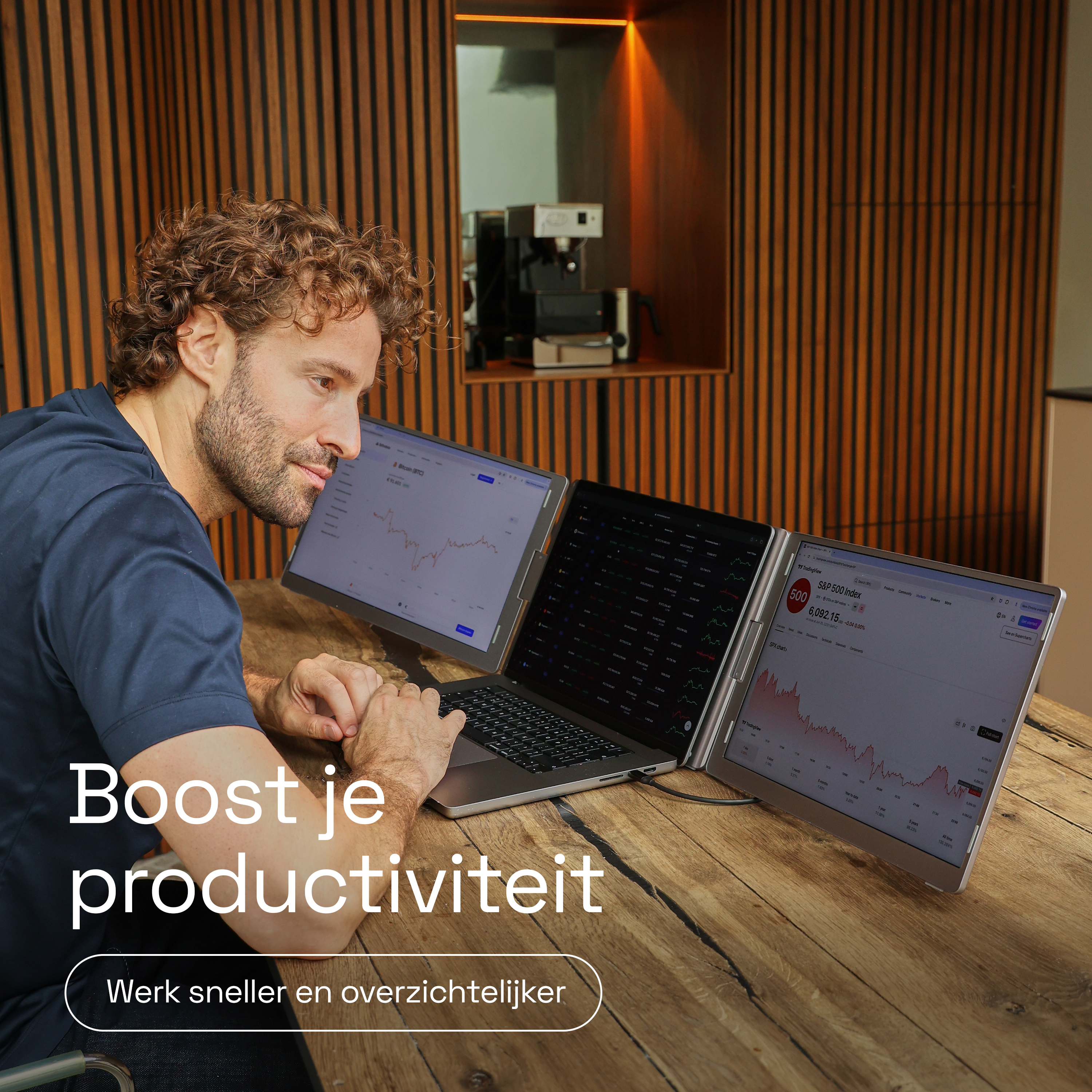 Een man werkt op een laptop met drie schermen die financiële gegevens weergeven.