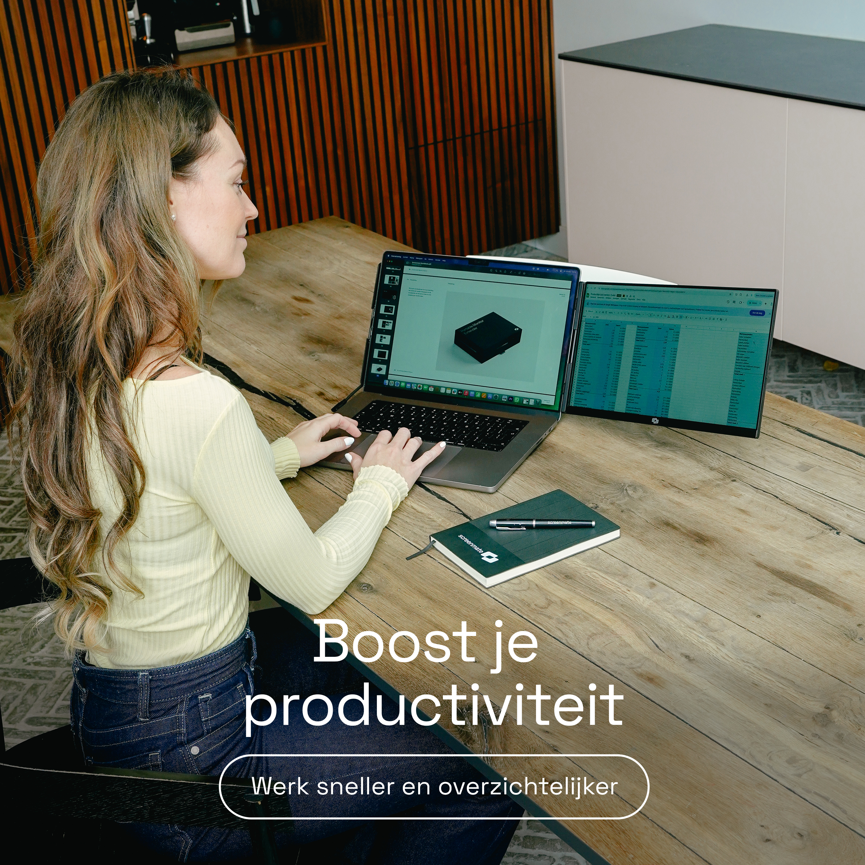 Vrouw werkt op laptops met dubbel scherm aan een houten tafel.