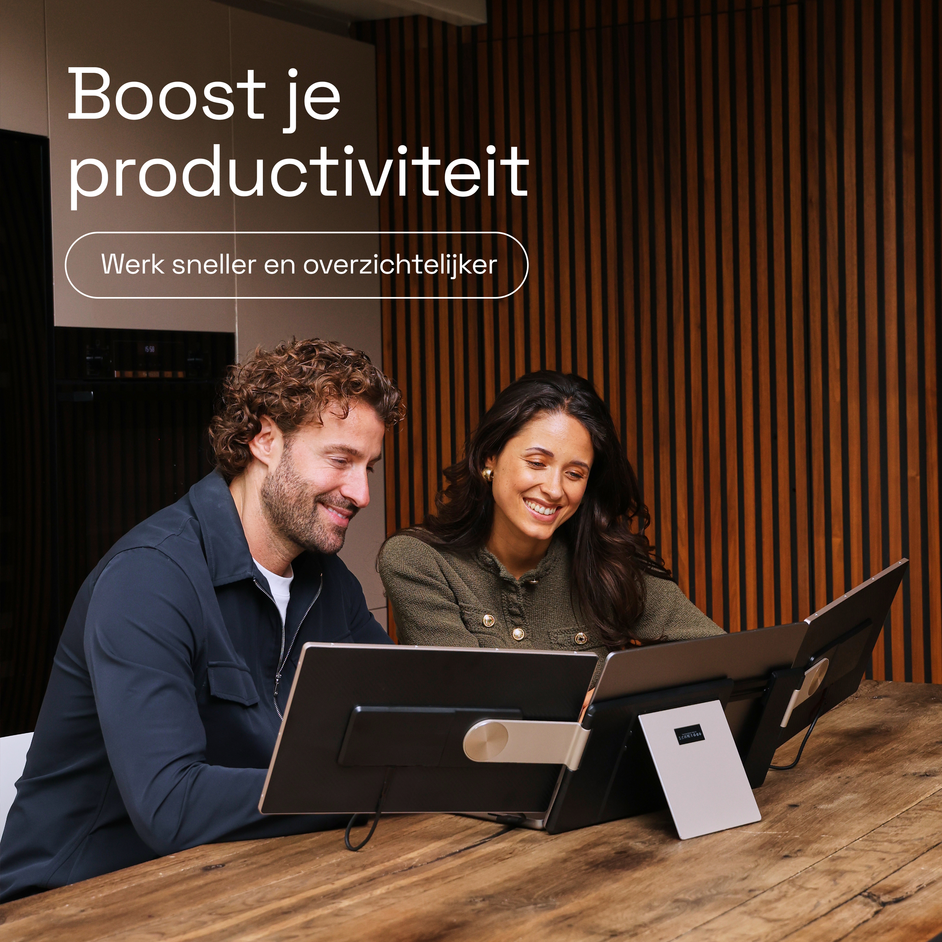 Homme et femme travaillent à table sur des moniteurs. Texte : Boostez productivité.