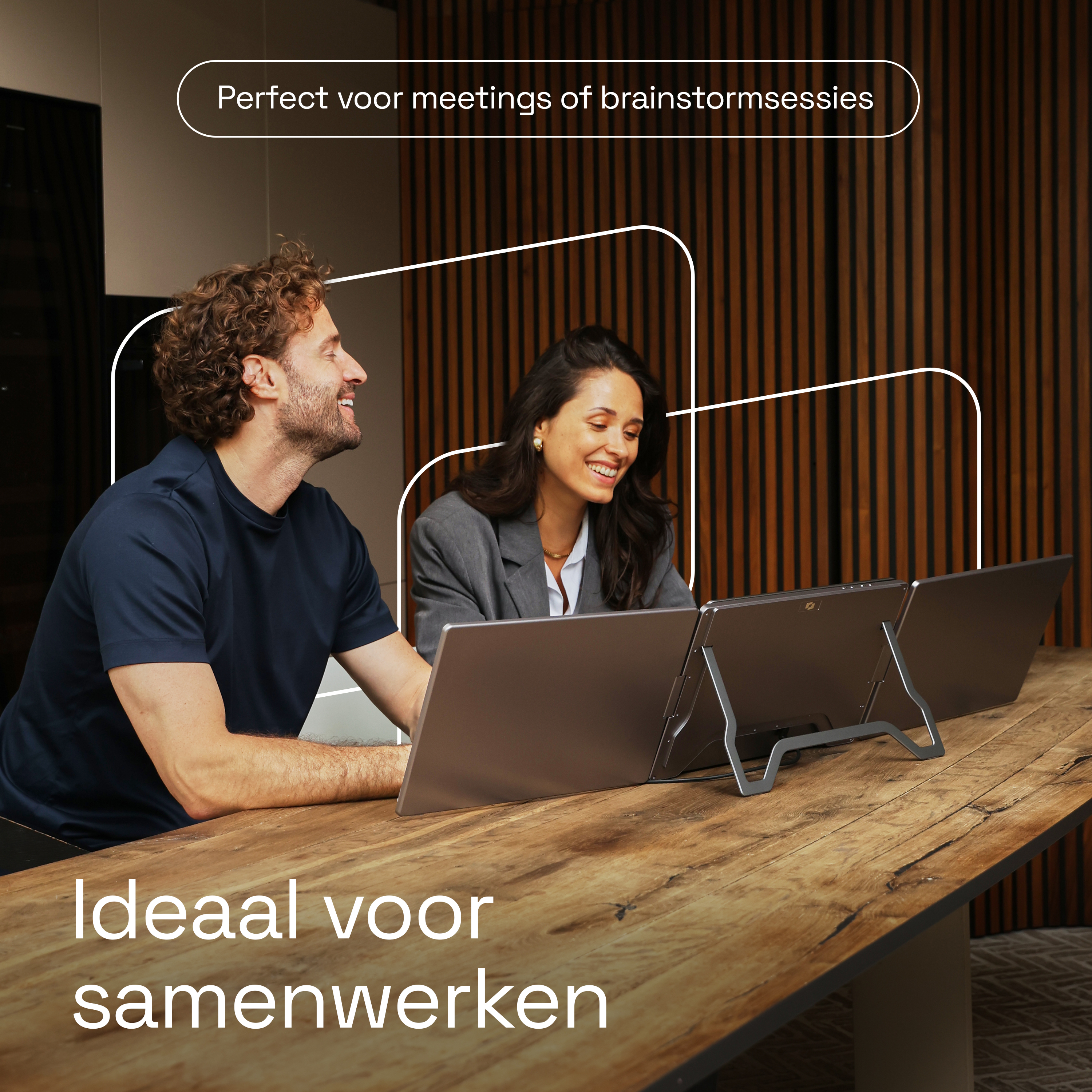 Man en vrouw werken op laptops aan een houten tafel.