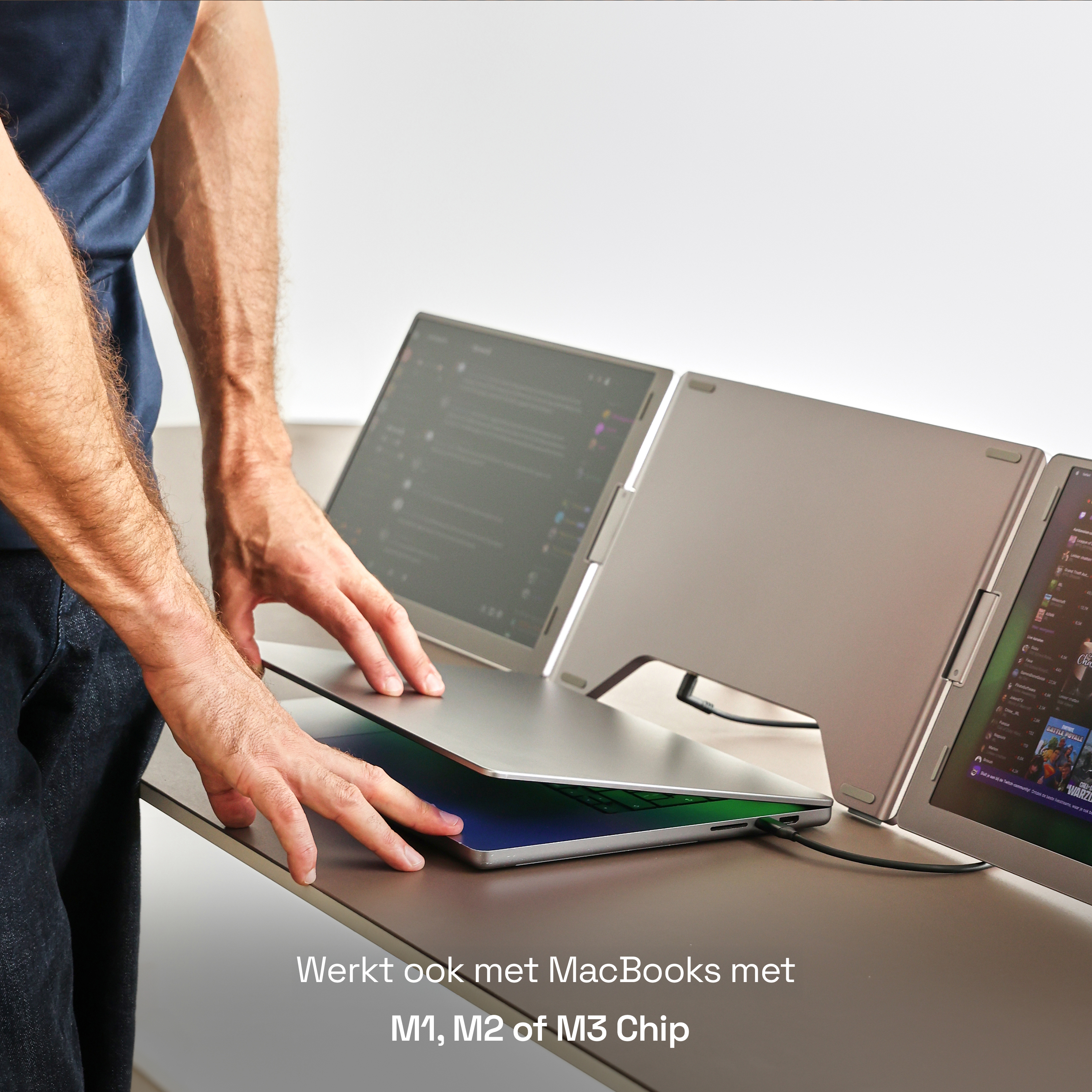 Man plaatst externe laptopschermen op een bureau met drie displays.