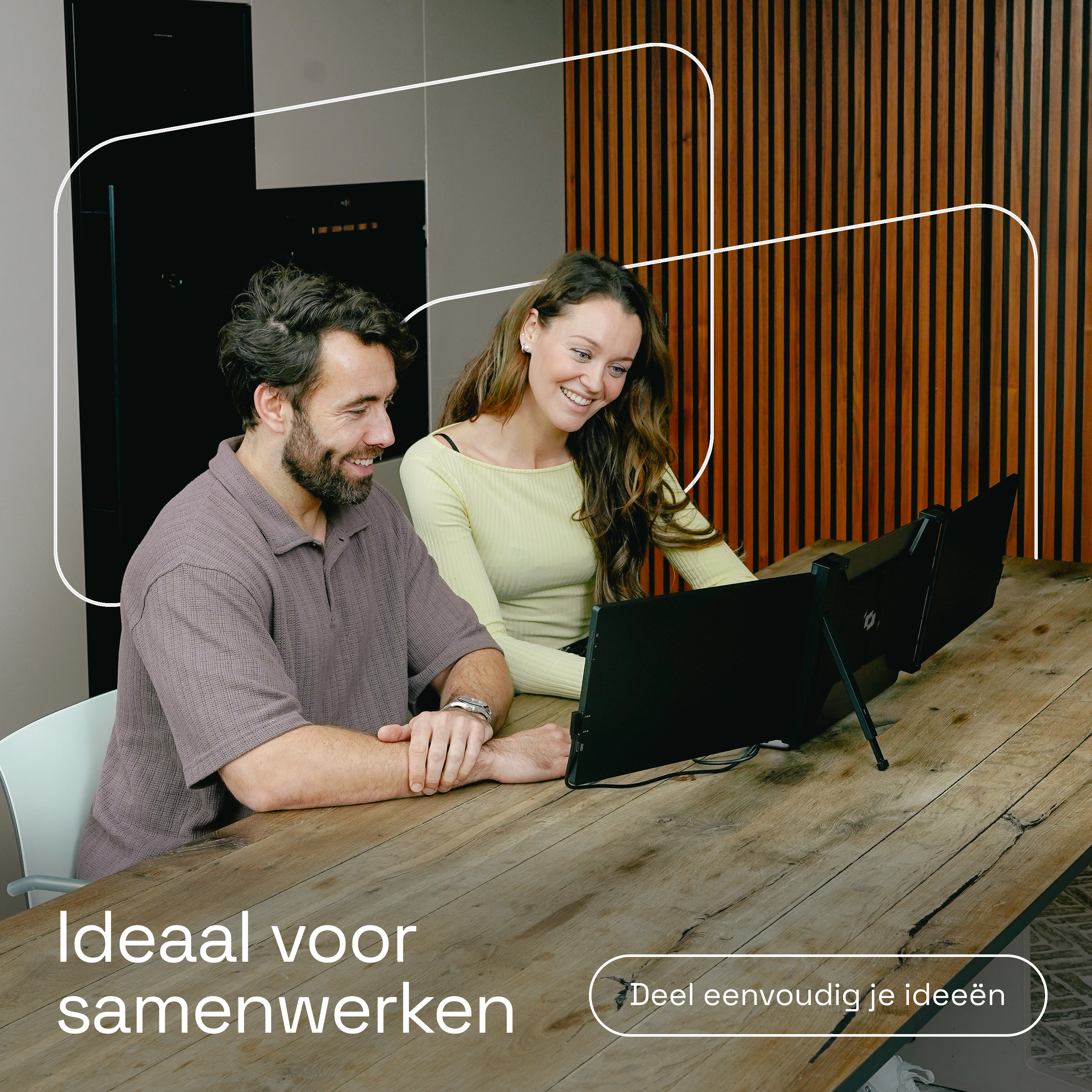 Man en vrouw werken aan laptops aan een houten tafel.