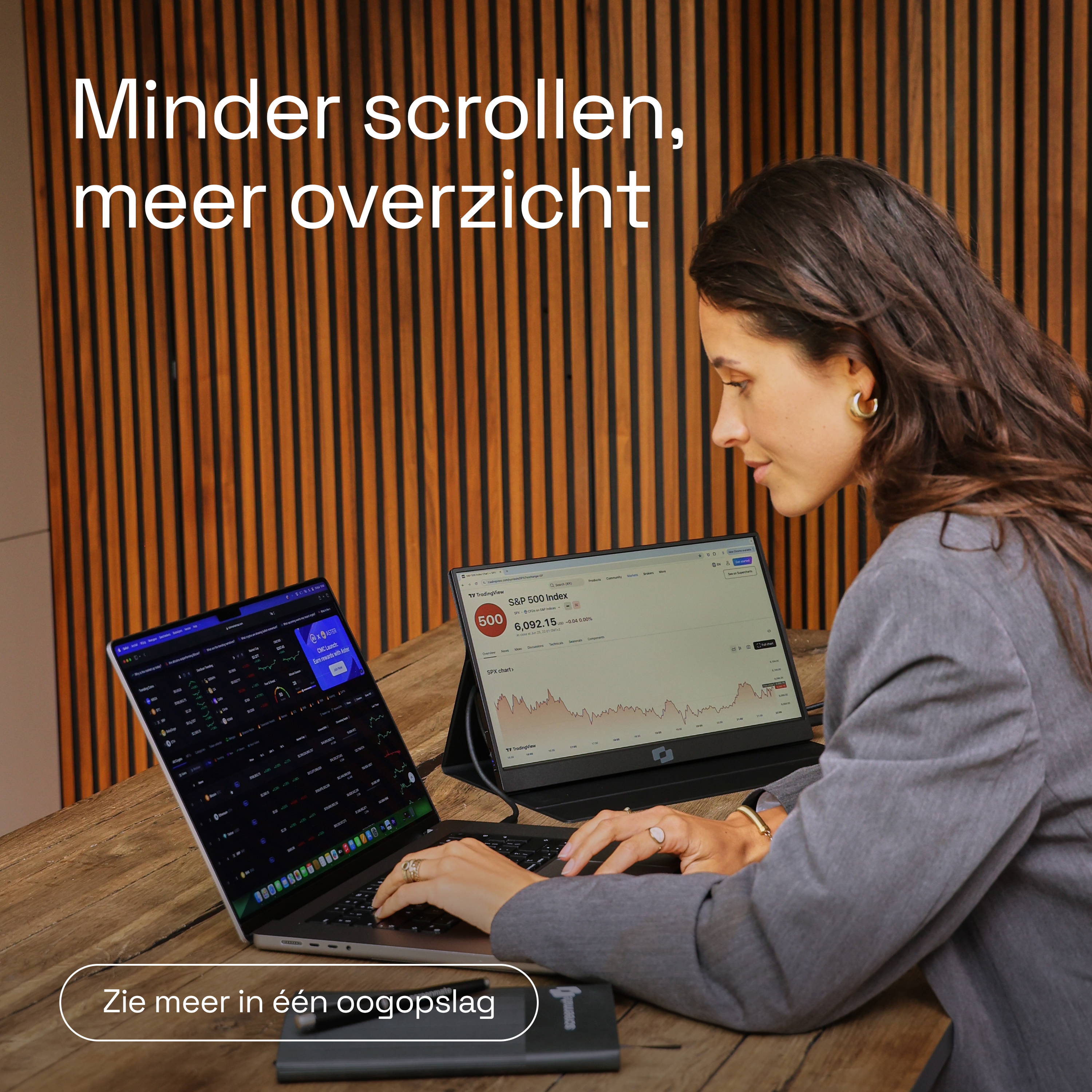 Vrouw met laptop en tweede monitor met financiële gegevens.