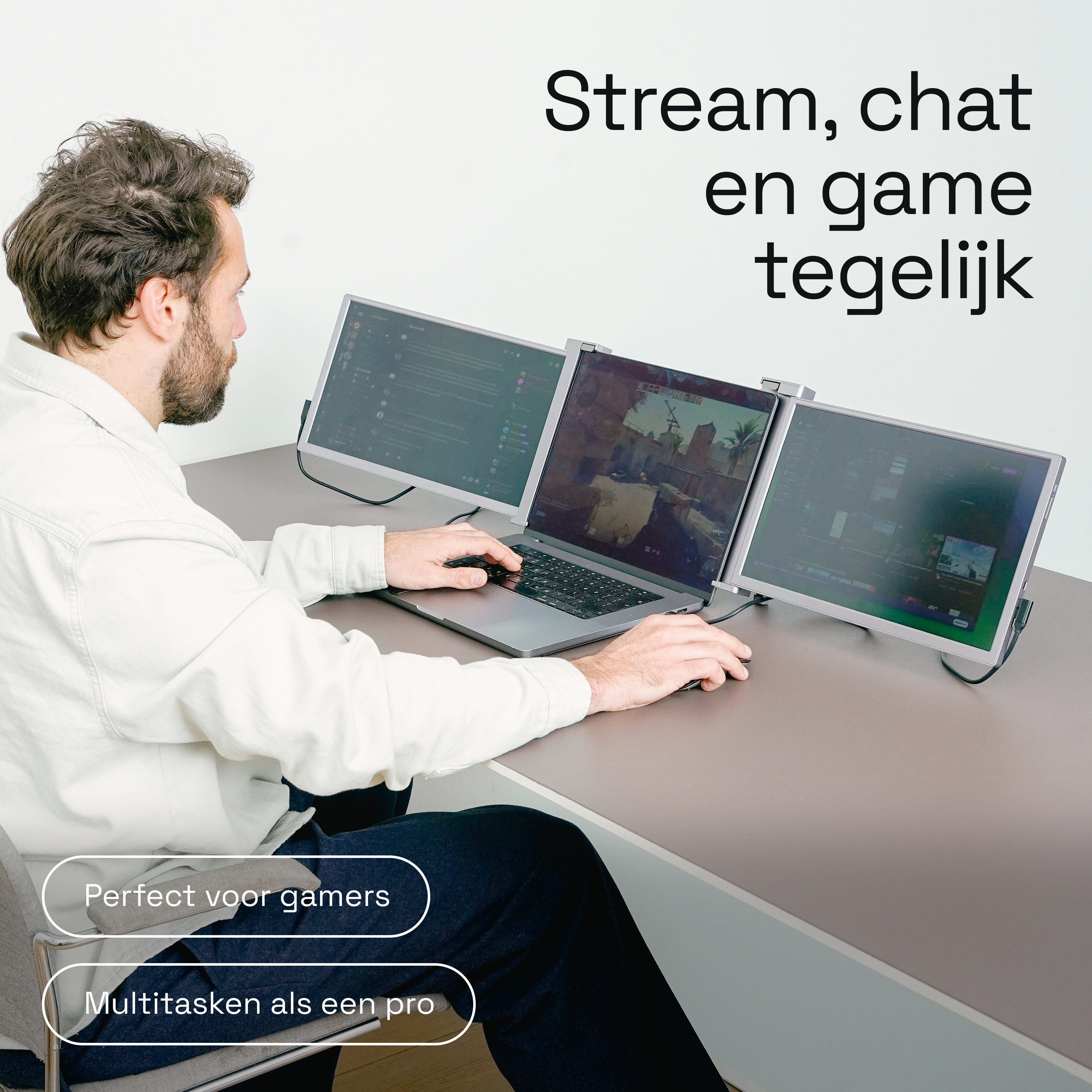 Man zit aan een bureau en gebruikt drie monitoren.