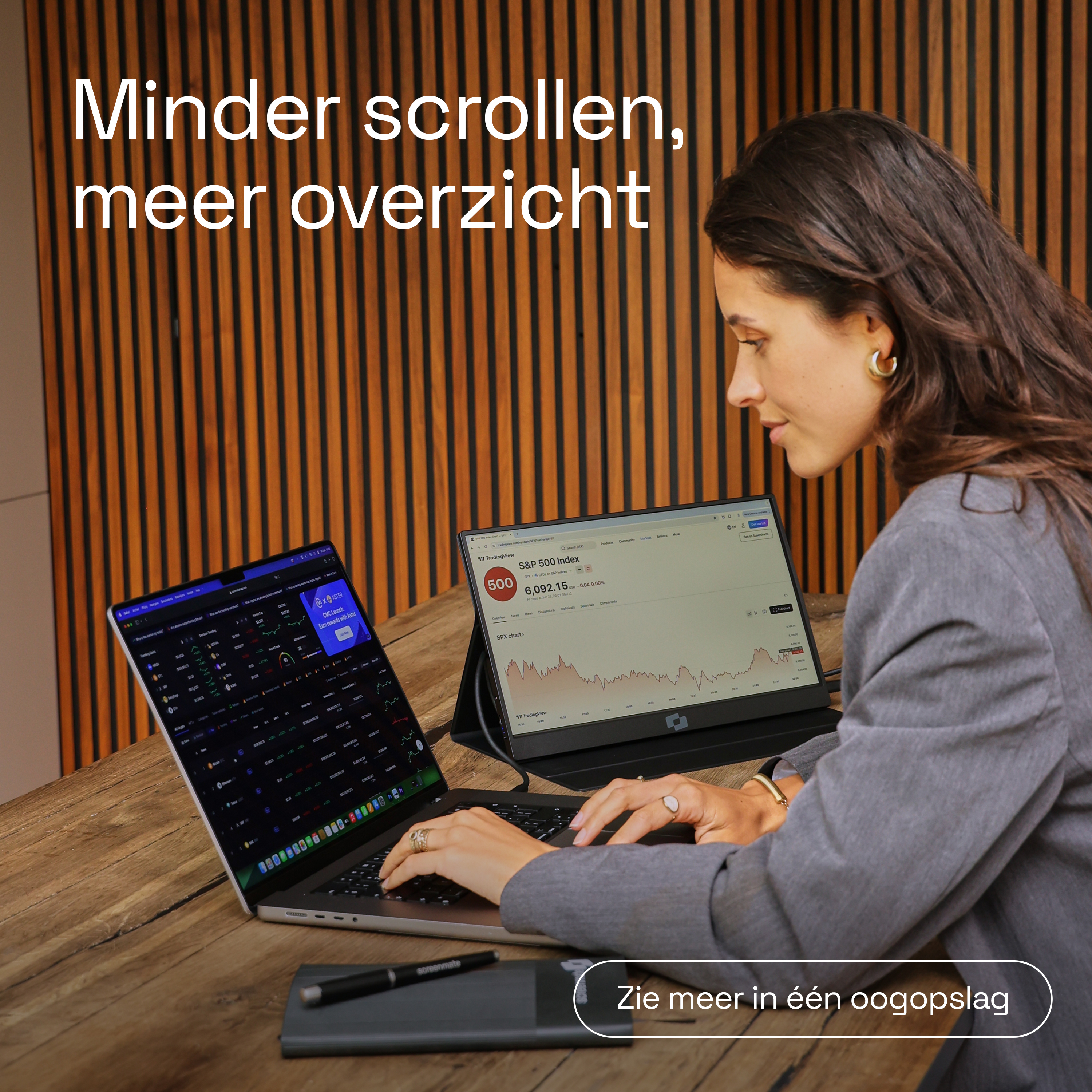 Une femme à un bureau avec deux écrans affichant des graphiques financiers.