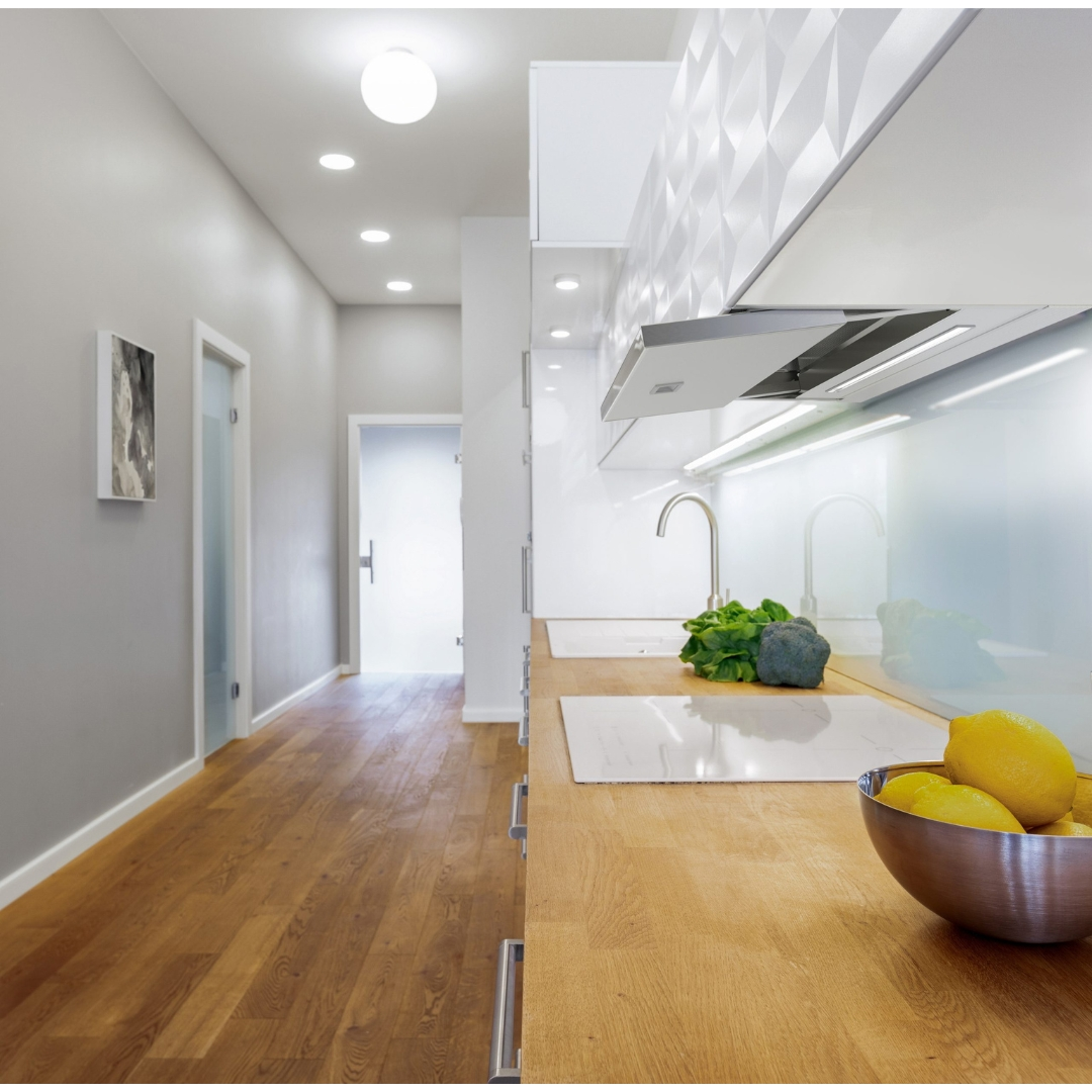 Cucina moderna con piano di lavoro in legno, verdure e limoni.