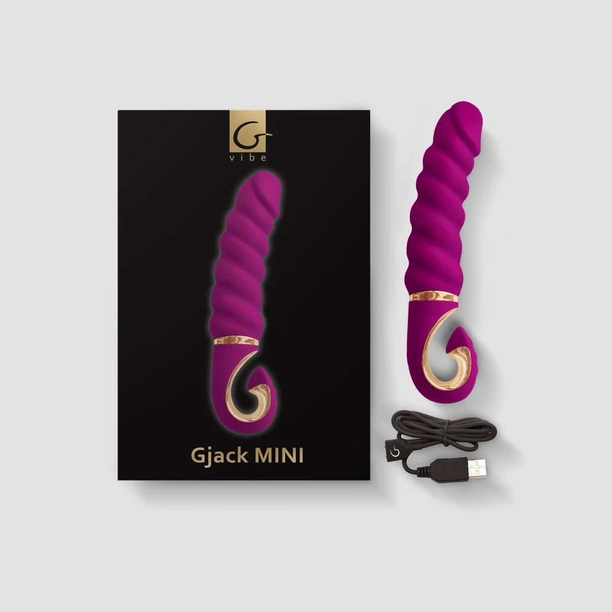 Lila Vibrator mit geripptem Design neben Verpackung und Ladekabel.