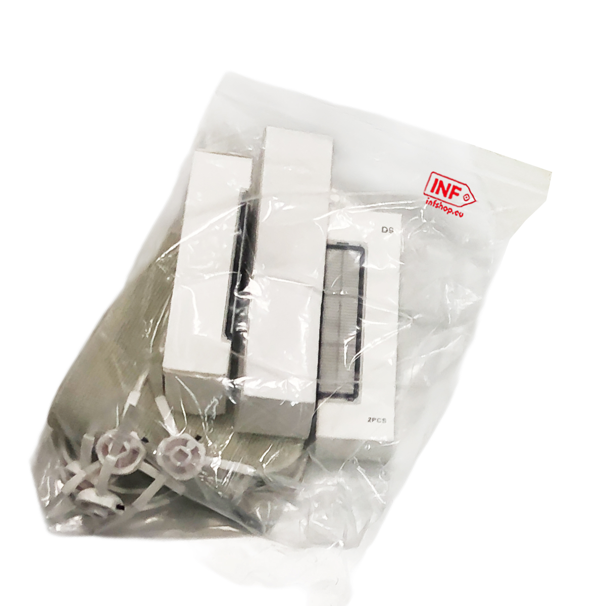 Białe pudełka i tkanina w przezroczystej torbie plastikowej, z małymi białymi częściami z przodu.