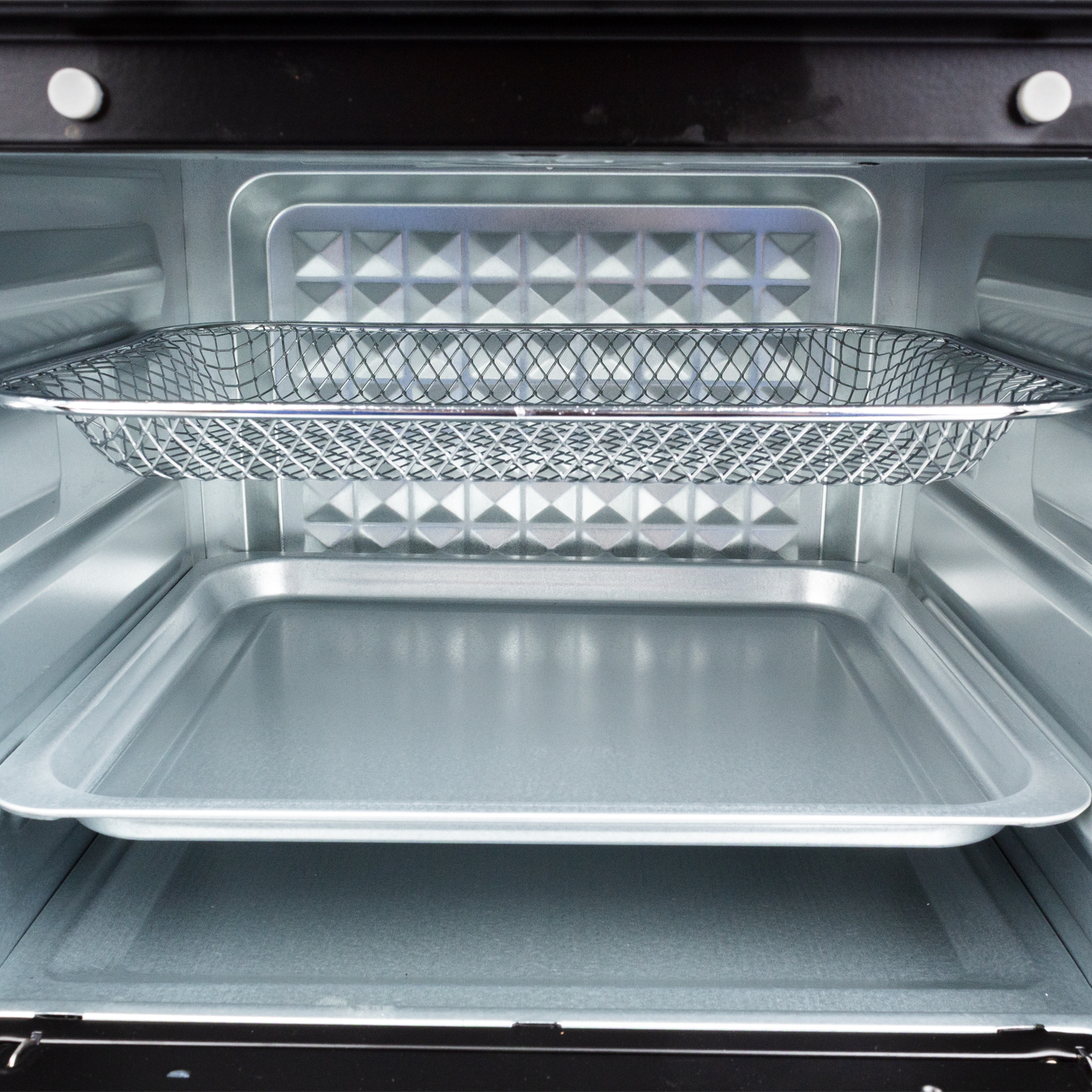 Interior de un horno vacío con una rejilla y una bandeja para hornear.