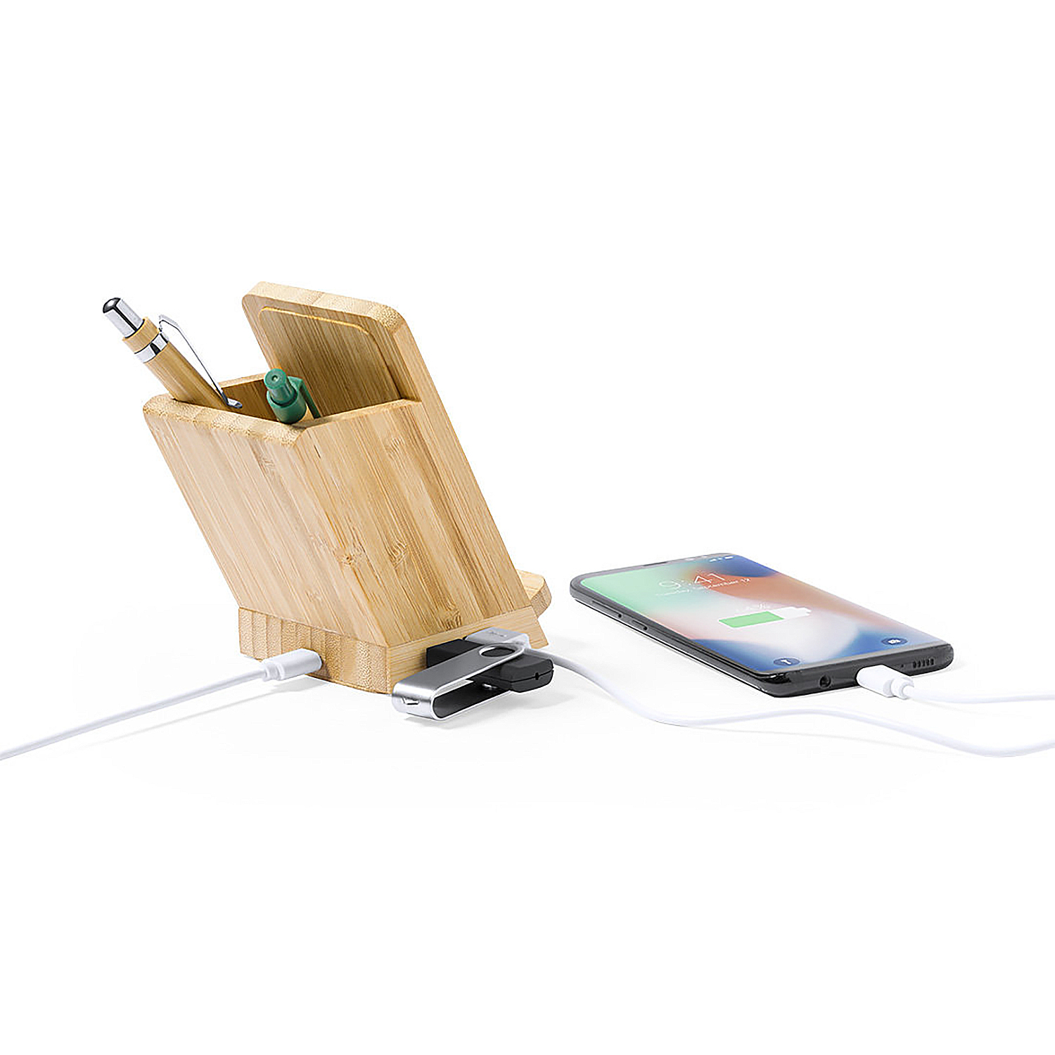 Un soporte de bambú con bolígrafos, unidad USB y smartphone cargando.