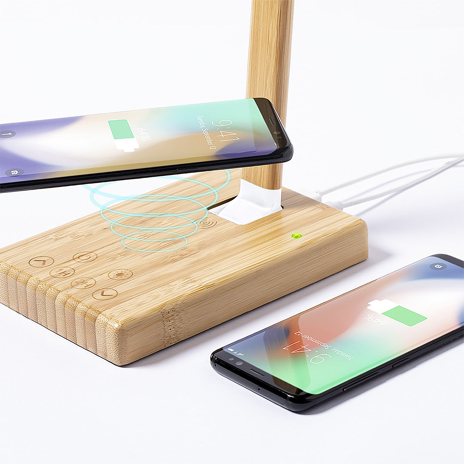 Un supporto di ricarica in legno con due smartphone in carica. Bobine di ricarica blu visibili.