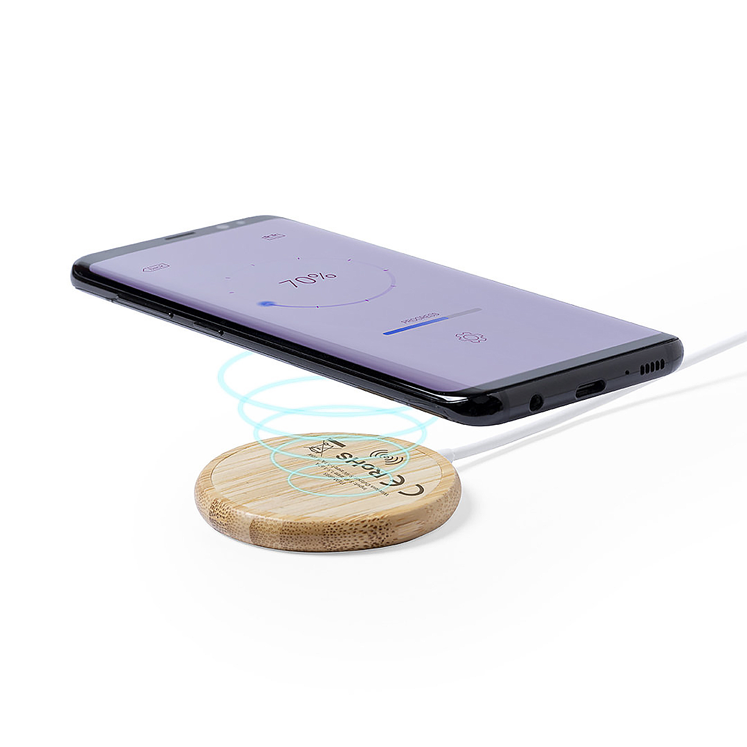 Un smartphone se carga inalámbricamente en una base de carga redonda de bambú.