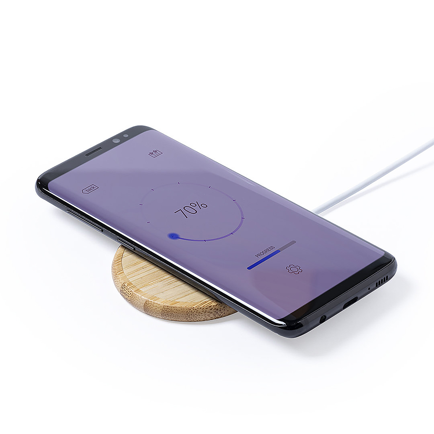 Un smartphone se carga inalámbricamente en una base de carga de madera.