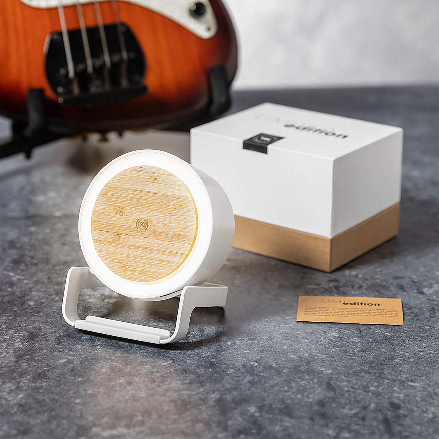Un altavoz blanco redondo con parte superior de madera e indicador.