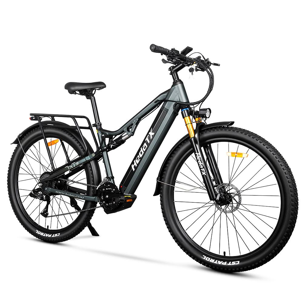 Ein graues E-Bike mit breiten Reifen, Federung und Gepäckträger.