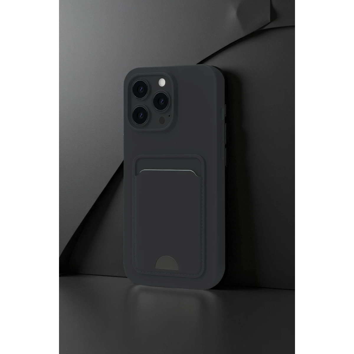 Koyu gri telefon kılıfı, kart yuvalı, koyu arka plan önünde.