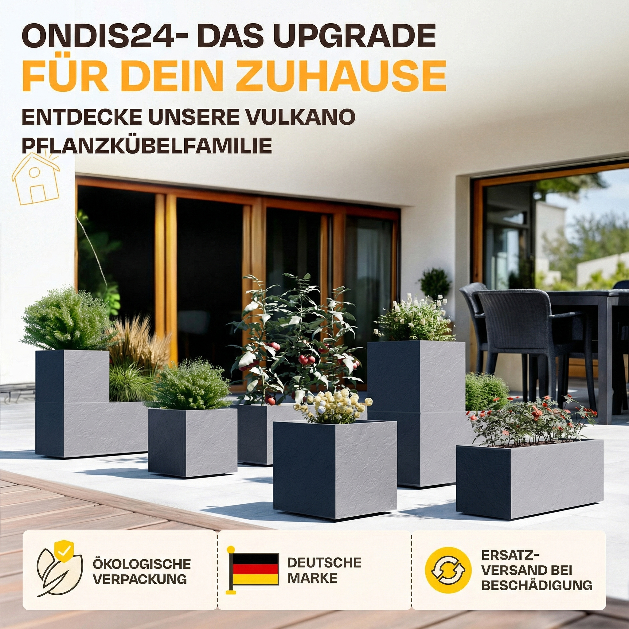 Graue Pflanzkübel mit Pflanzen auf einer Terrasse mit Möbeln im Hintergrund.