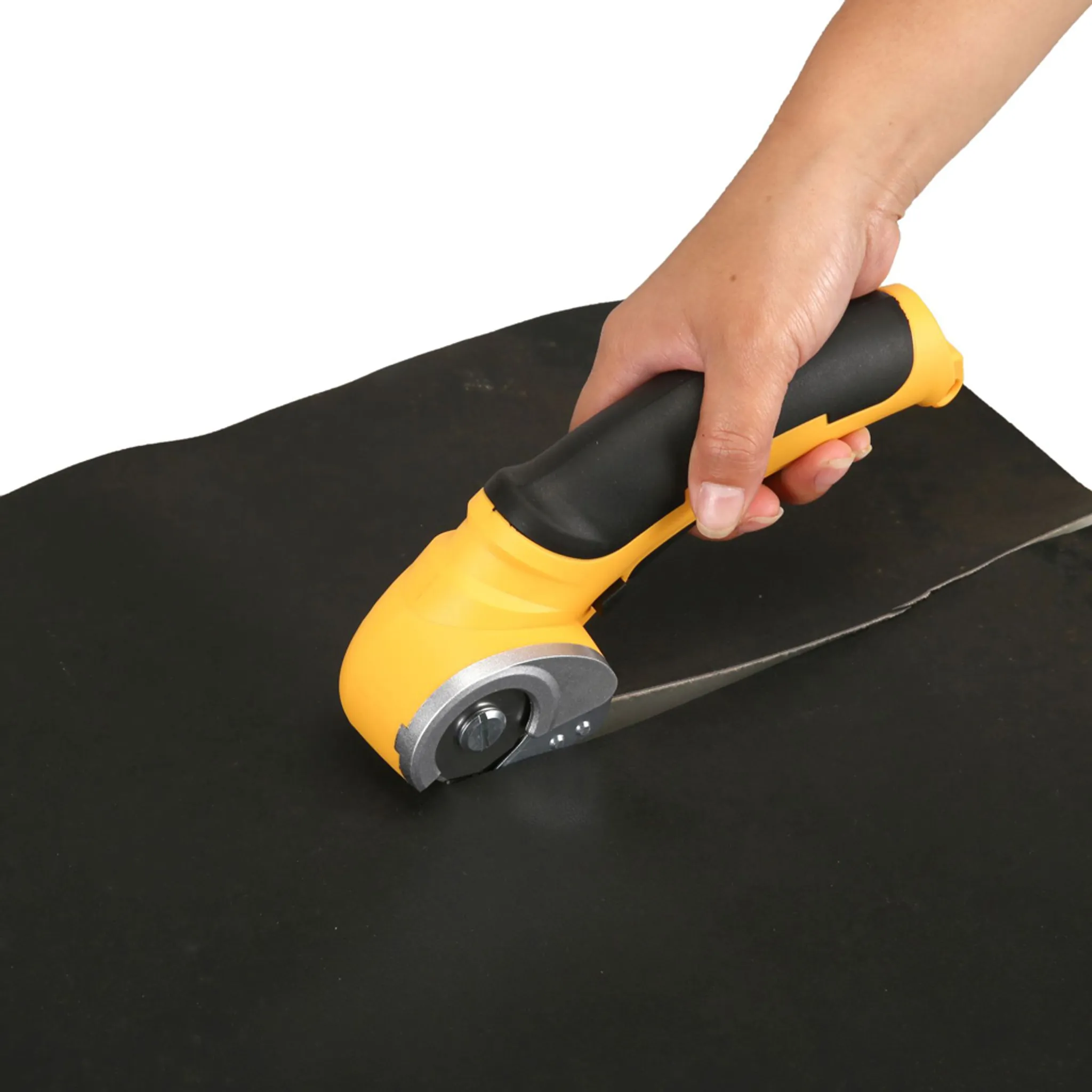 Eine Hand hält einen gelben und schwarzen Rollschneider, der schwarzes Material schneidet.