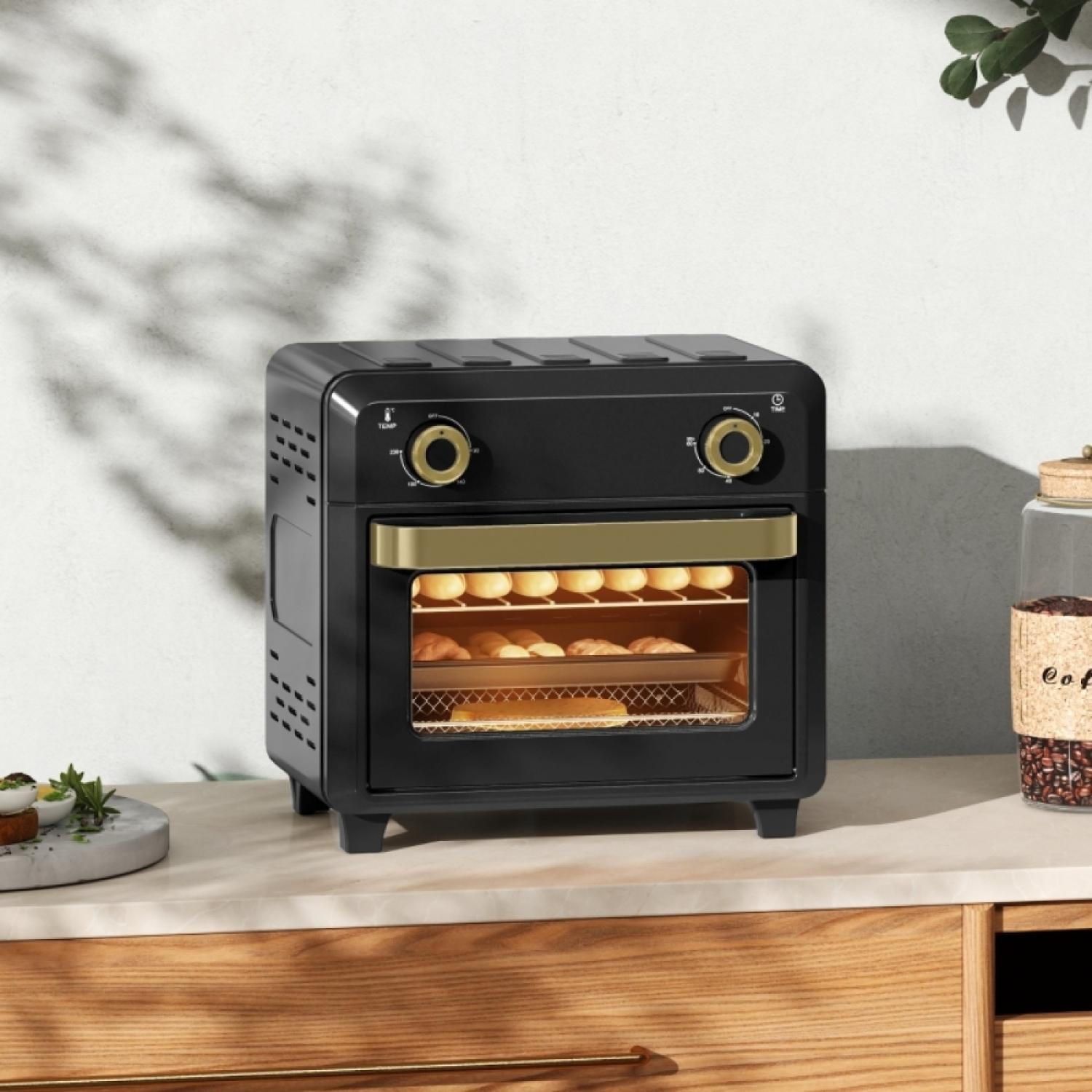 Schwarzer Minibackofen mit goldenen Akzenten, gefüllt mit Gebäck.