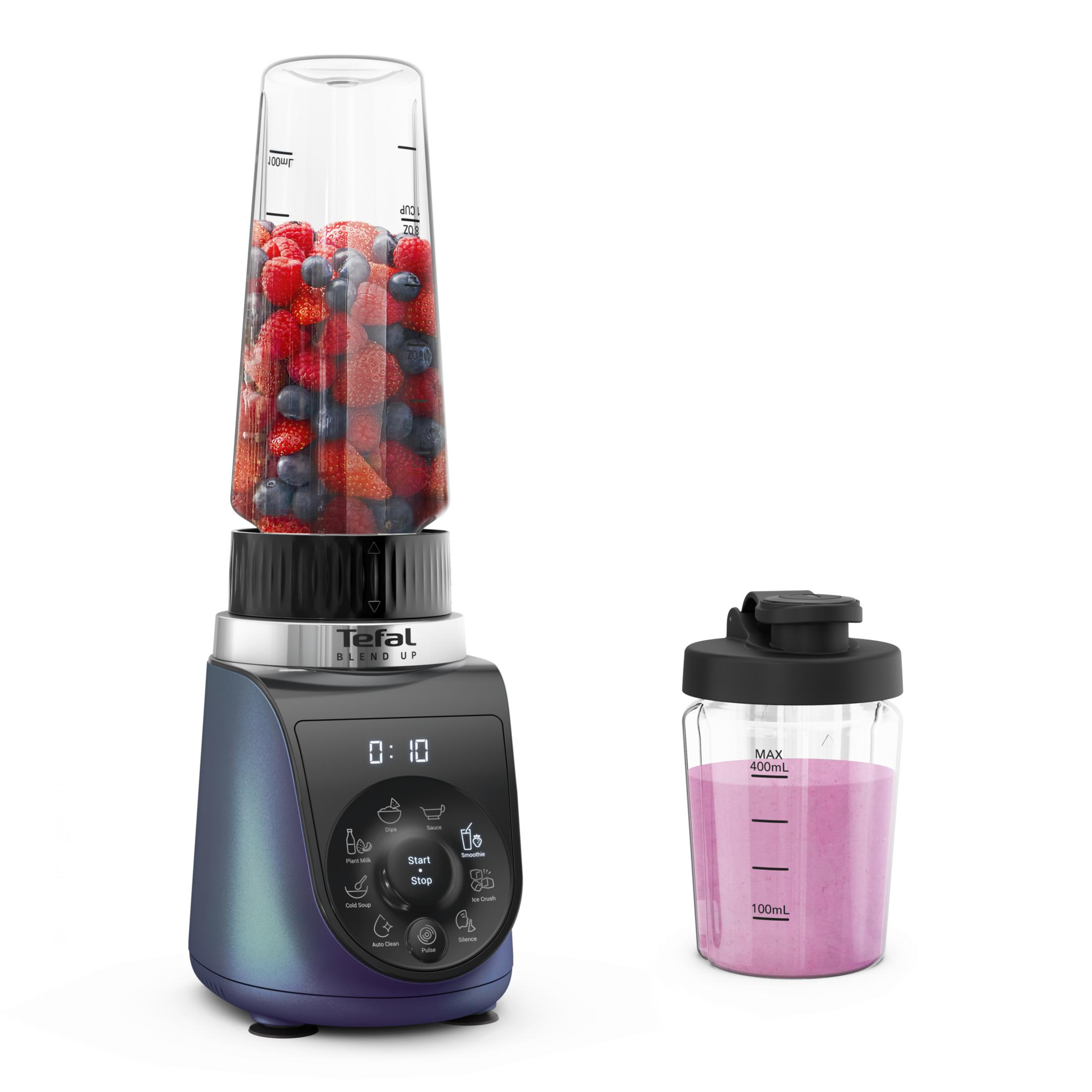 Un frullatore blu con frutta nel suo contenitore e un bicchiere di frullato rosa accanto.